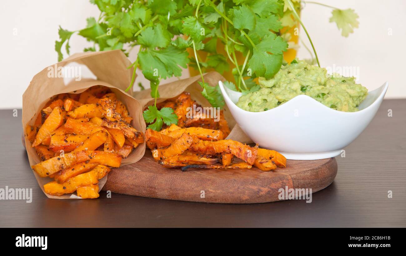 Süßkartoffeln mit Guacamole Dip verziert mit frischem Koriander Stockfoto