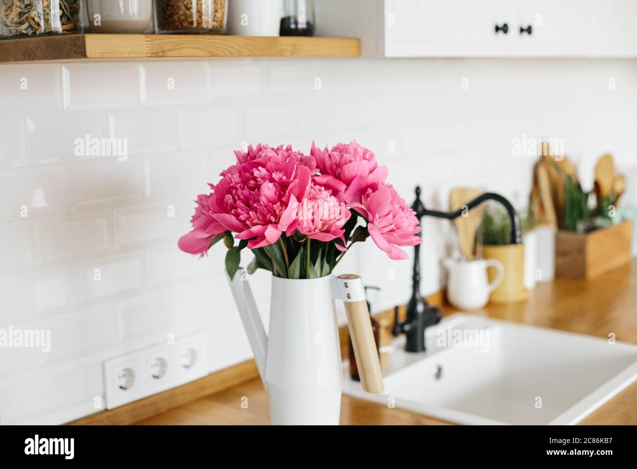 Pfingstrosen Blumen in Vase auf saubere weiße Küche in modernem Stil, Küchendetails. Nachhaltiges Wohnen umweltfreundliche Küche Stockfoto