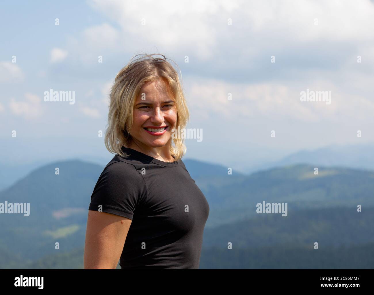 Schönes Mädchen reist in einem engen T-Shirt hoch in den Bergen Stockfoto
