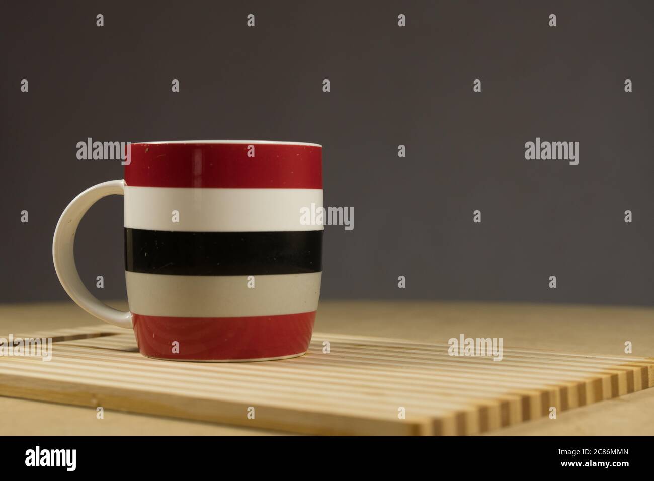 Rot-weiß-blauer Becher auf blauem Hintergrund. Das Konzept eines freundlichen Unternehmens, einer großen Familie, Treffen mit Freunden für eine Tasse Tee oder Kaffee Stockfoto