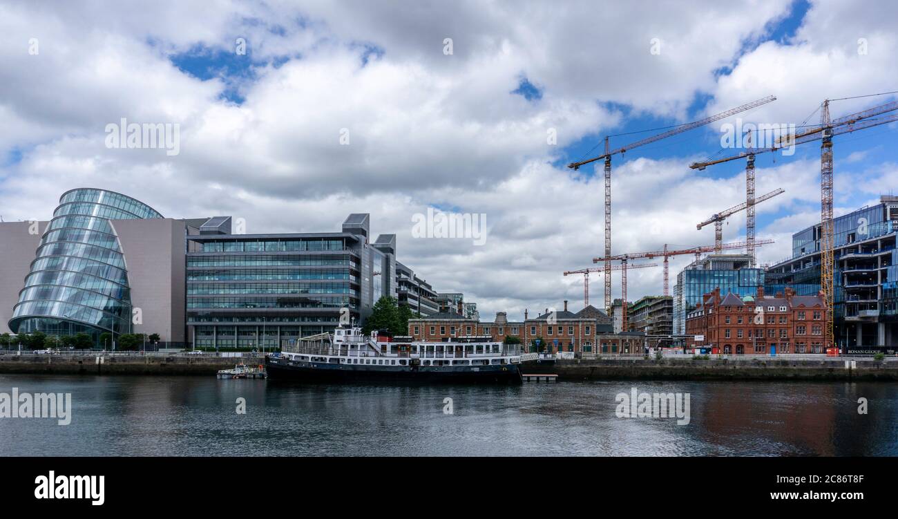 Über den Bauarbeiten ragen hoch aufragende Krane am North Wall Quay des Liffey River, links das Convention Center. Stockfoto