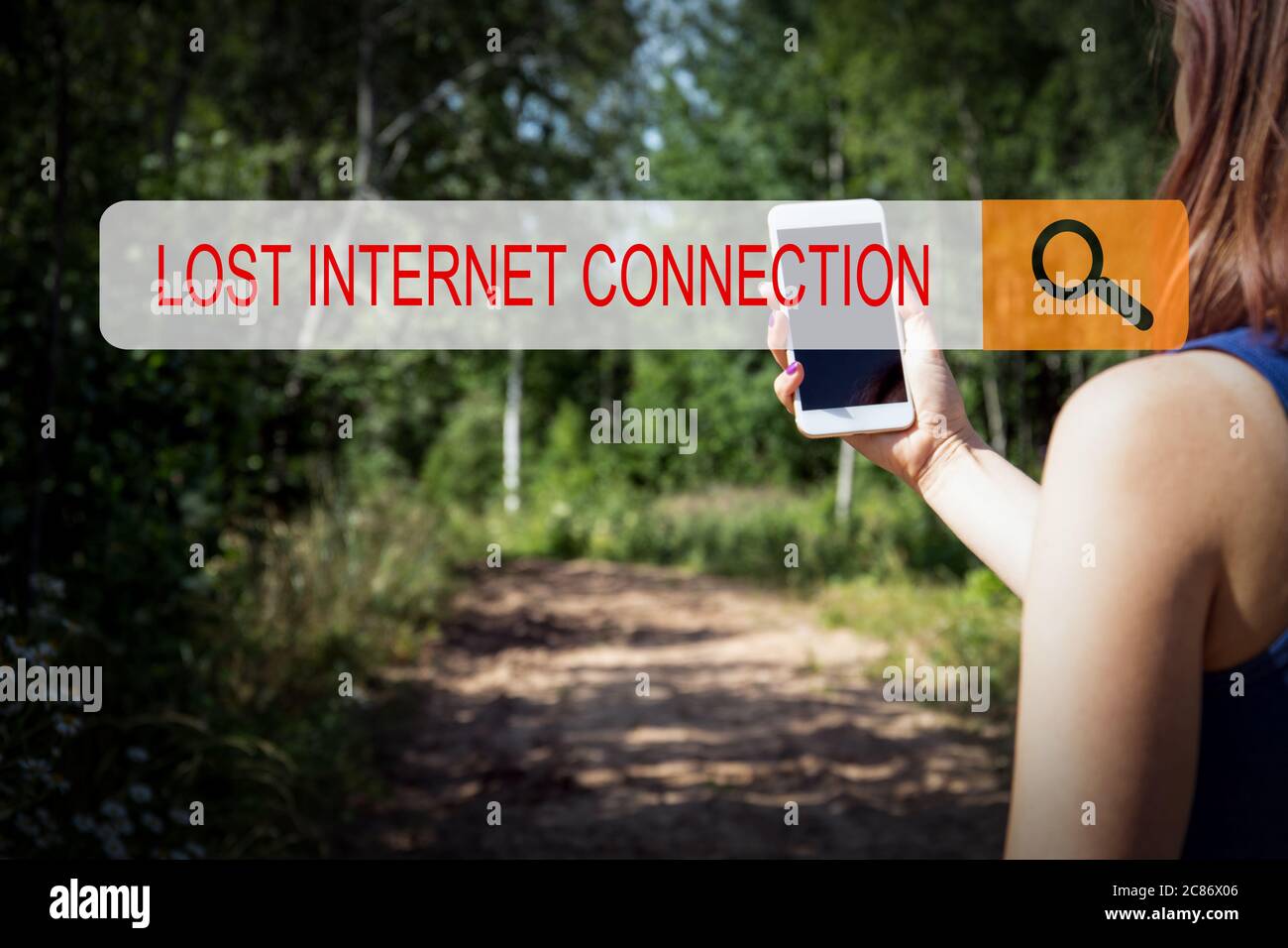 KONZEPT FÜR DIE INTERNETVERBINDUNG VERLOREN. Eine Frau mit Handy im Wald, an einem unbewohnten Ort fernab der Zivilisation Stockfoto