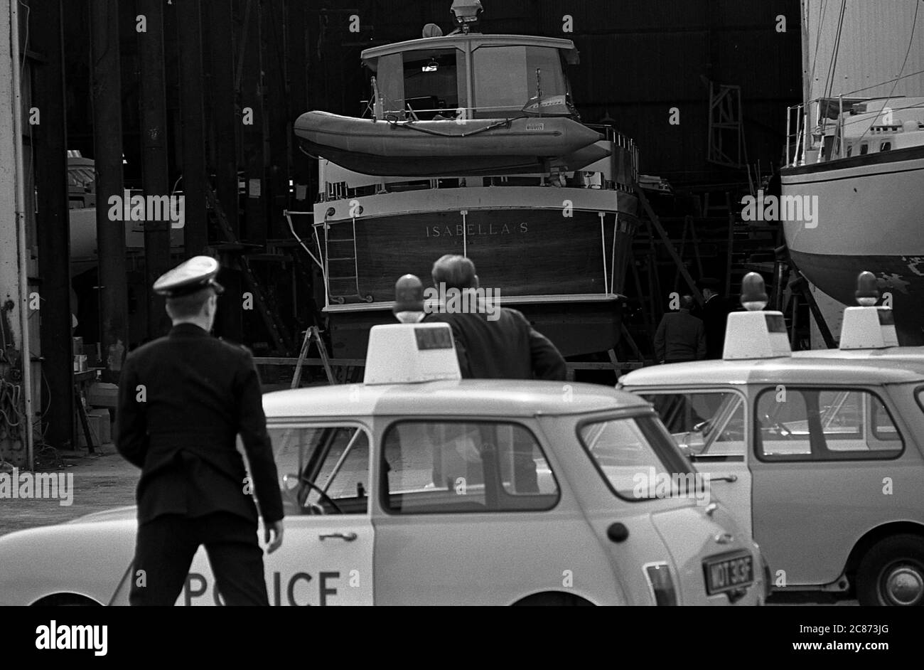 AJAXNETPHOTO. APRIL 1970. GOSPORT, ENGLAND. - BOMBENBETRUG WÄHREND DES PRINCESS-BESUCHES - POLIZEI SUCHE CAMPER & NICHOLSON'S WERFT UND SCHUPPEN NACH ALARM EINER BOMBE, DIE WÄHREND DES BESUCHES VON HRH PRINZESSIN ALEXANDRA, DIE EHRENVOLLE LADY OGILVY, DIE VOR ORT WAR, UM DIE YACHT LUTINE ZU NENNEN GEPFLANZT WURDE. ALARM STELLTE SICH ALS SCHWINDEL HERAUS. FOTO: JONATHAN EASTLAND/AJAXREF:357031 202206 15 Stockfoto