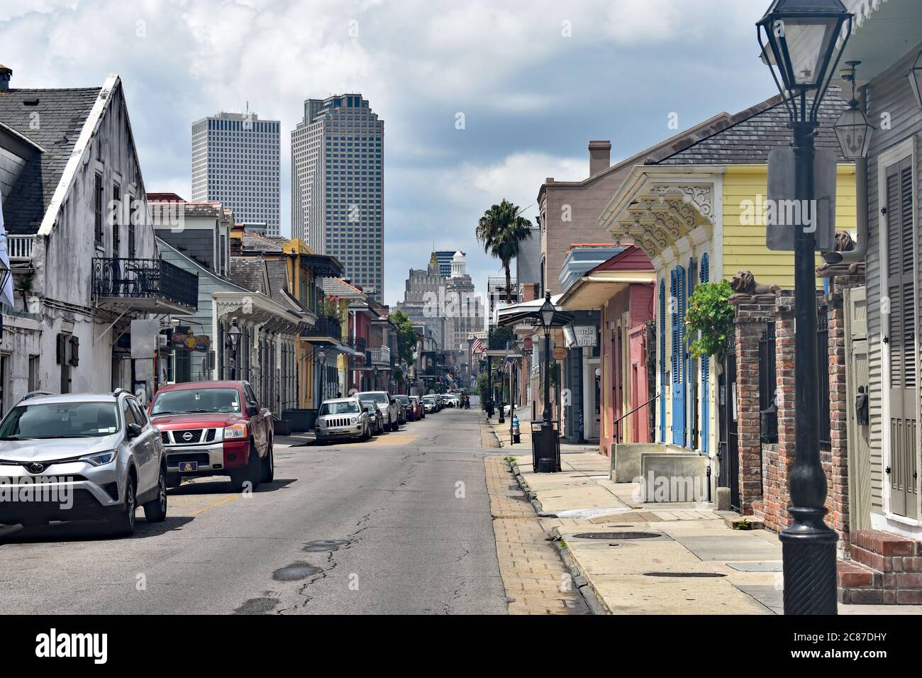 Das ruhige Ende der Bourbon Street mit Blick auf die Innenstadt von New Orleans. Bunte Kreolarchitektur und Autos, die auf einer Seite der Straße geparkt sind. Stockfoto