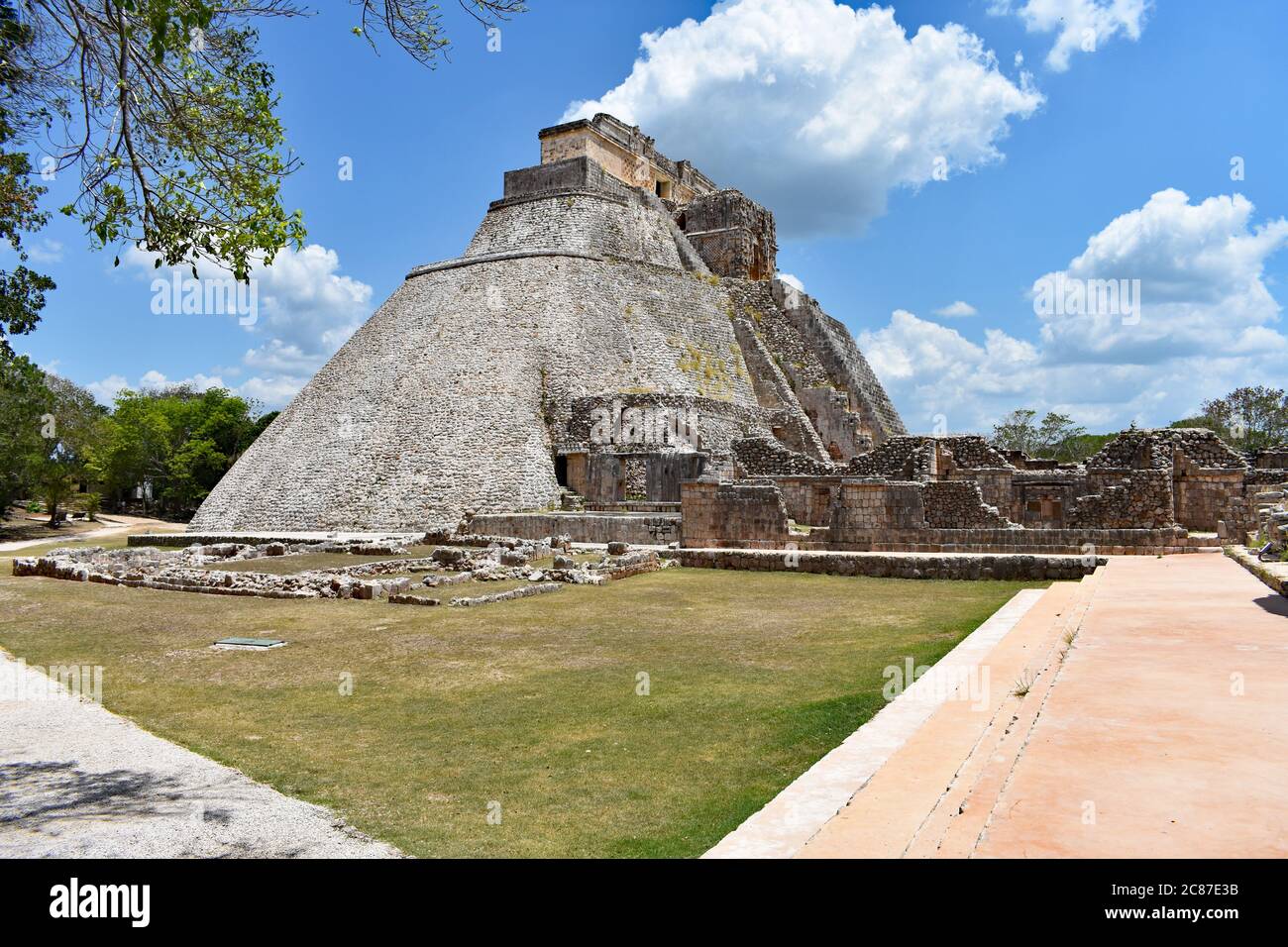 Die Pyramide des Magiers mit umliegenden Ruinen und Pfaden in der antiken Maya-Stadt Uxmal auf der Halbinsel Yucatan, Mexiko. Stockfoto