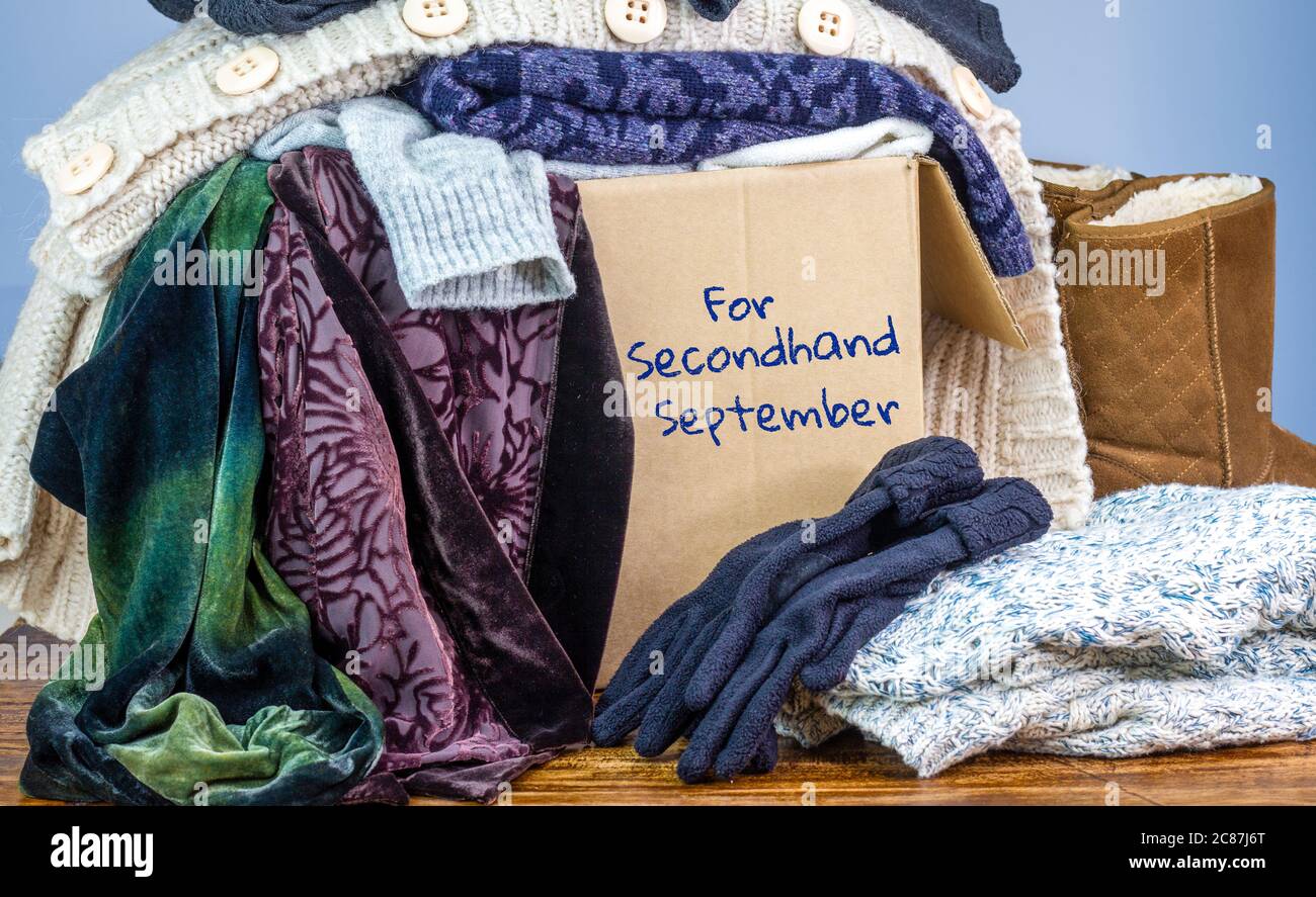 Vorgeliebte Kleidung in einer Box, die für Second Hand September markiert ist, wiederverwenden recyceln Kleidung durch Austausch für nachhaltige Mode und Null Abfall Stockfoto