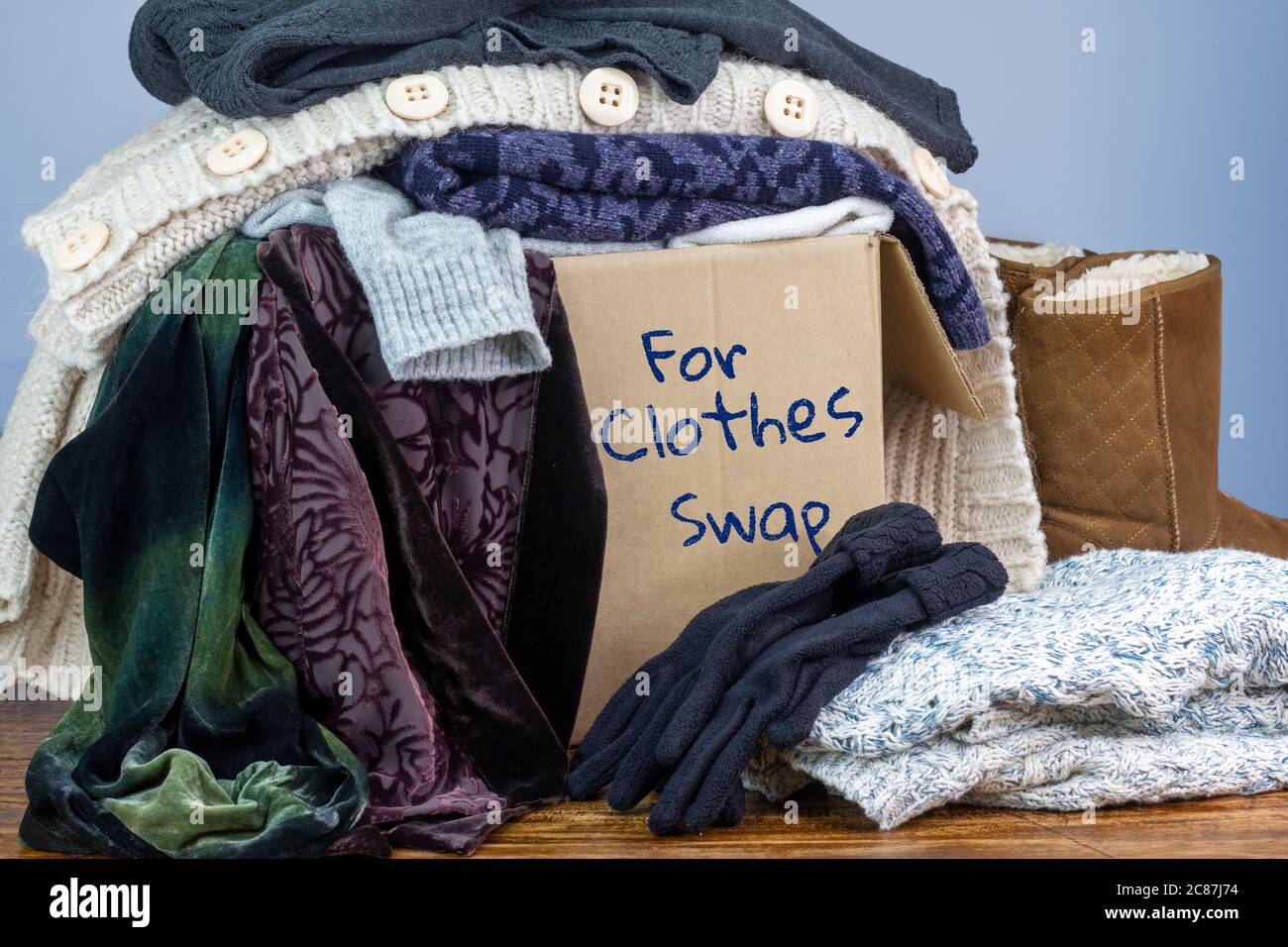 Gebrauchte Kleidung in einer Box markiert für Clothes Swap, wiederverwenden recyceln Kleidung durch Austausch für nachhaltige Mode und Null Abfall Stockfoto