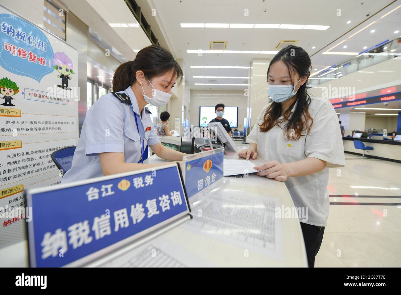 (200722) -- FUZHOU, 22. Juli 2020 (Xinhua) -- EIN Mitarbeiter beantwortet Fragen eines Unternehmensvertreters zur Kreditreparatur in einem Steuerbüro-Service-Center im Bezirk Taijiang, Fuzhou, südöstlich der Provinz Fujian in China, 21. Juli 2020. Die Steuerbehörde der Provinz Fujian hat 2020 ein aktiveres und dynamischeres Kreditmanagement für Steuerzahler eingeführt. Im Rahmen des neuen Mechanismus werden Marktteilnehmer aufgefordert, Anträge einzureichen und einige ihrer negativen Steuerauszahlungen zu erstellen. Wenn ihre Kredite repariert wurden, könnten die beteiligten Unternehmen eine reibungslosere Handhabung von ta erwarten Stockfoto