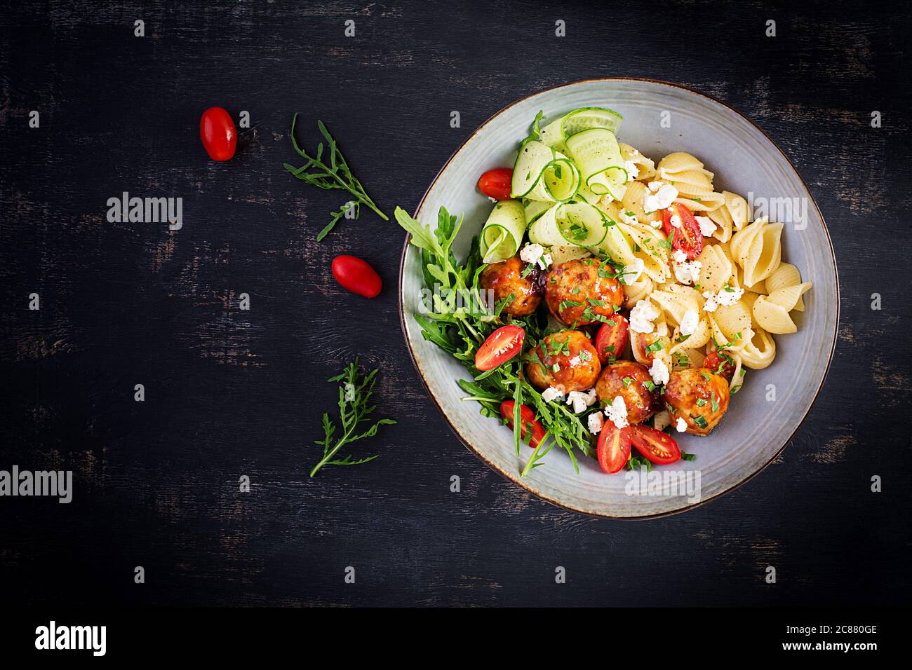 Italienische Pasta. Conchiglie mit Fleischbällchen, Feta-Käse und Salat auf dunklem Hintergrund. Abendessen. Draufsicht, Overhead. Slow Food Konzept Stockfoto