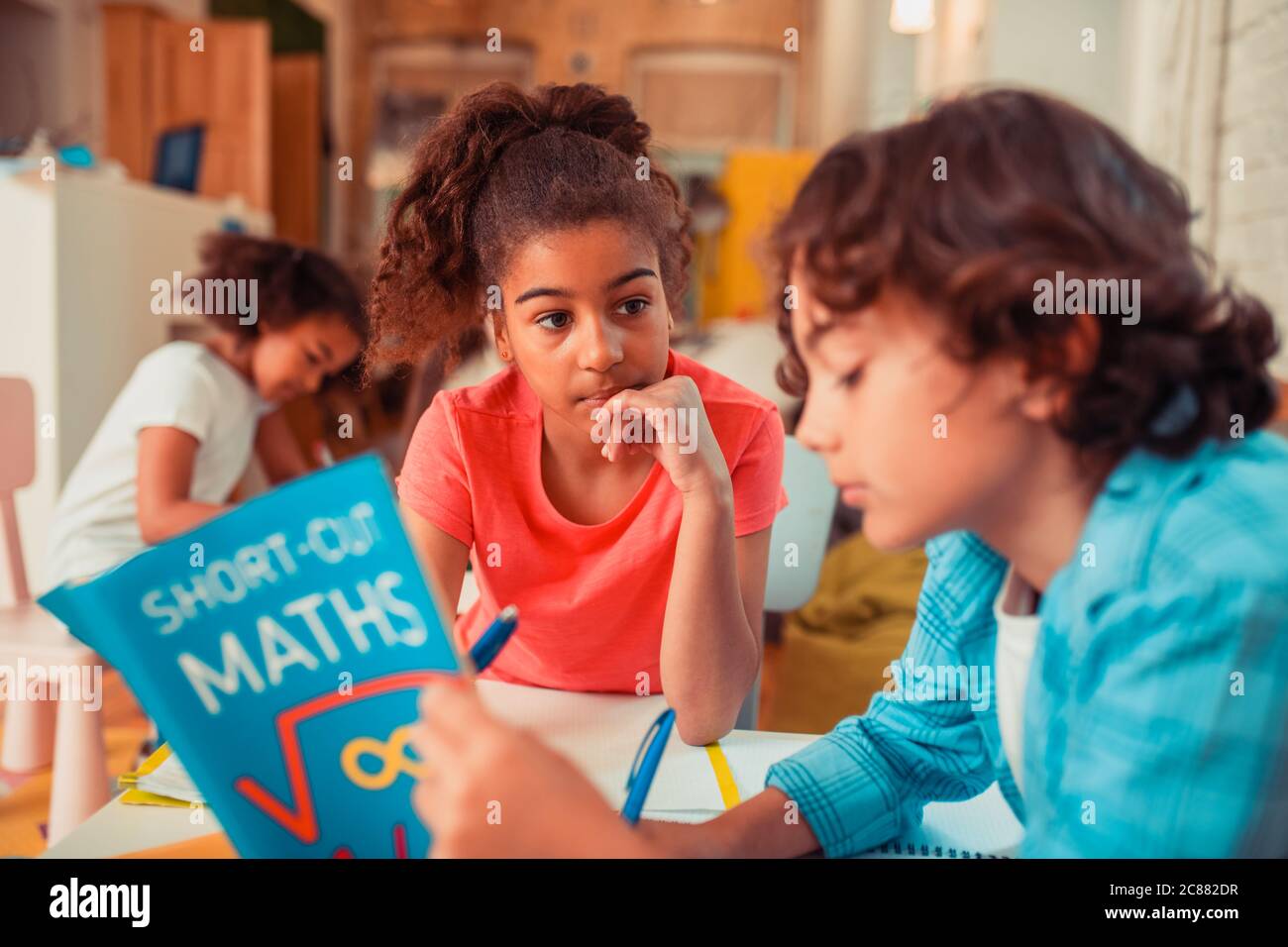 Nachdenkliches Mädchen, das Mathematik mit ihrem Klassenkameraden lernt Stockfoto