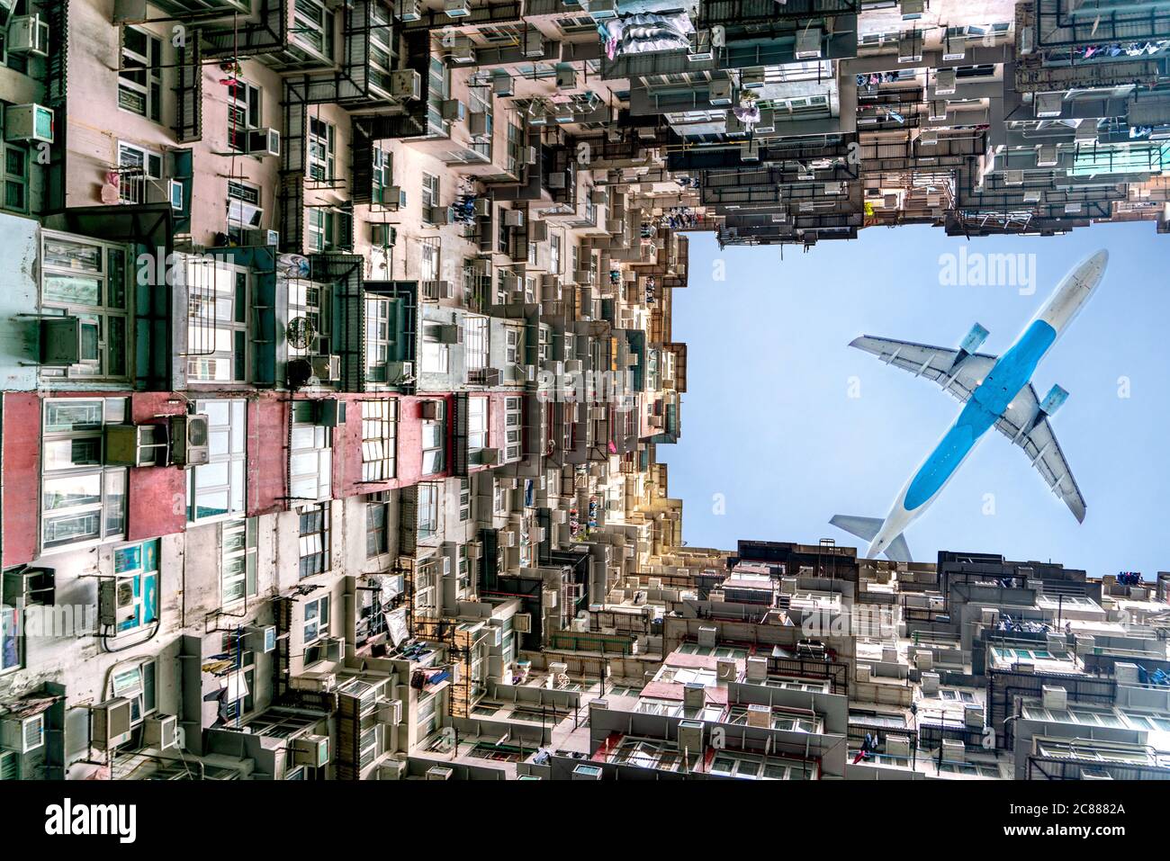 Das Flugzeug fliegt über das Berghaus in der Nähe von Tai Koo in Hongkong. Überfülltes altes Retro-Gebäude Stockfoto