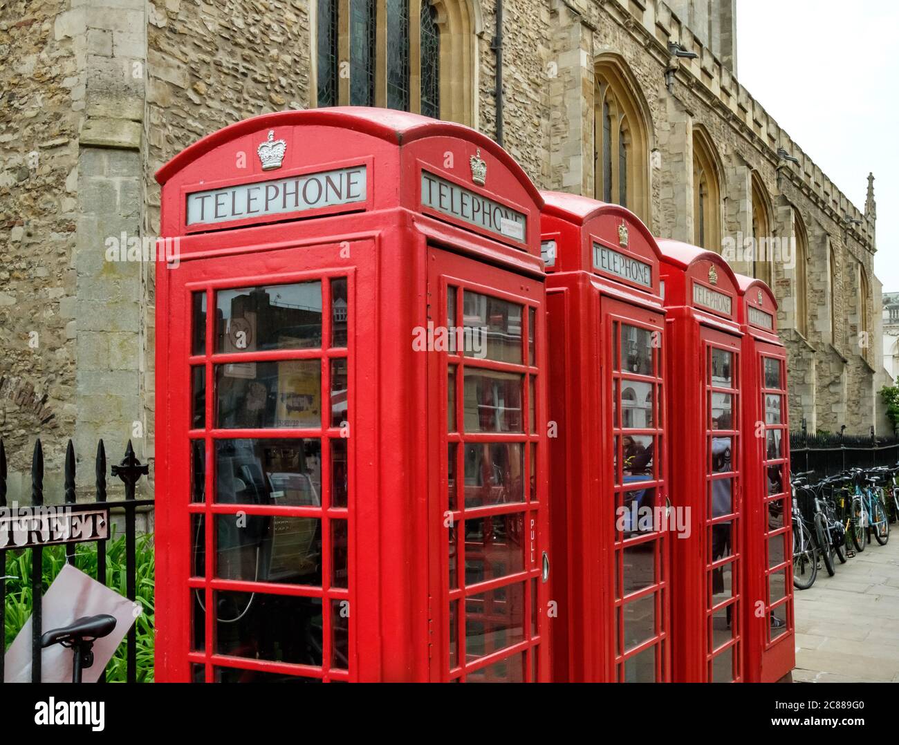Alte britische Telefonzellen gesehen ausgerichtet durch eine große Kirche in der Universitätsstadt Cambridge. Stockfoto