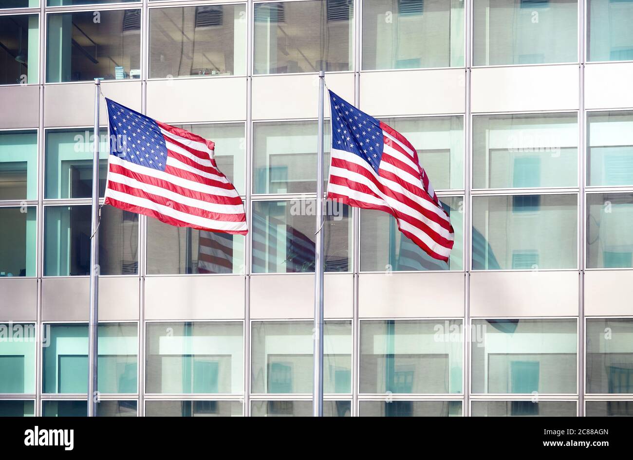 Zwei amerikanische Flaggen vor einem Bürogebäude, New York City, USA. Stockfoto