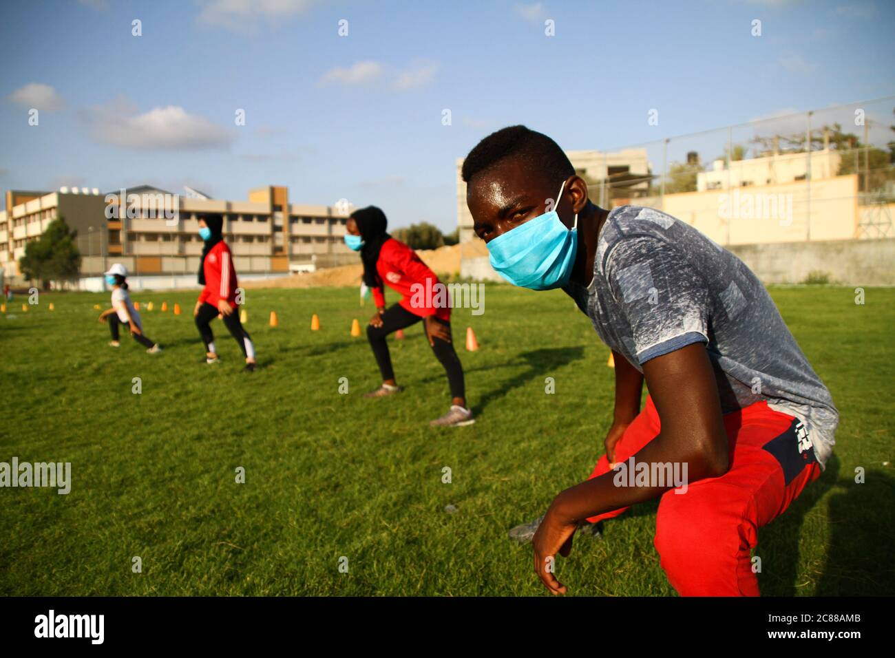21. Juli 2020: Gaza, Palästina. 21. Juli 2020. Palästinensische Kinder und Jugendliche besuchen eine Sportveranstaltung im Freien in der Stadt Beit Lahia im nördlichen Gazastreifen. Die Teilnehmer führten Übungen zur Verbesserung ihrer körperlichen Fähigkeiten wie Kraft, Beweglichkeit und Ausdauer durch und trugen Gesichtsmasken als Schutzmaßnahme gegen die Ausbreitung des Coronavirus. Die Veranstaltung wurde vom Beit Lahia Youth Club organisiert, um die Sportpraxis und die Entwicklung internationaler Leichtathletik-Fähigkeiten von Kindern und Jugendlichen aus Gazan zu unterstützen.Quelle: Ahmad Hasaballah/IMAGESLIVE/ZUMA Wire/Alamy Live News Stockfoto
