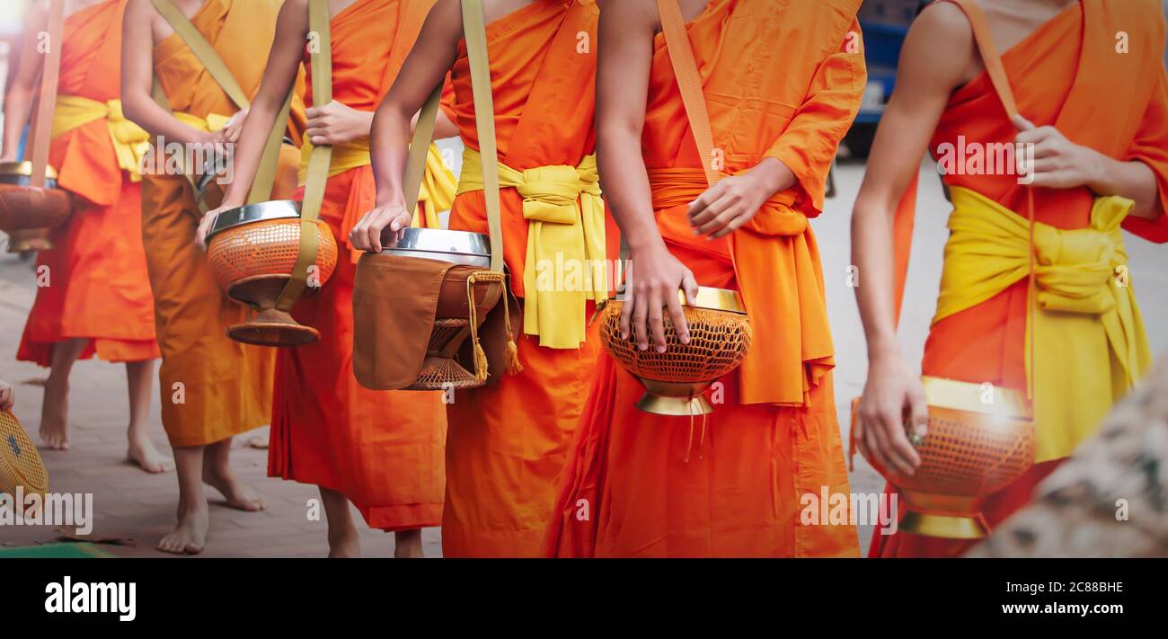 In der Nähe von buddhistischen Novizen Mönche, die ihre Almosenschüsseln tragen, um am frühen Morgen Almosenschüsseln zu machen. Luang Prabang, Laos. UNESCO-Weltkulturerbe Stadt. Stockfoto