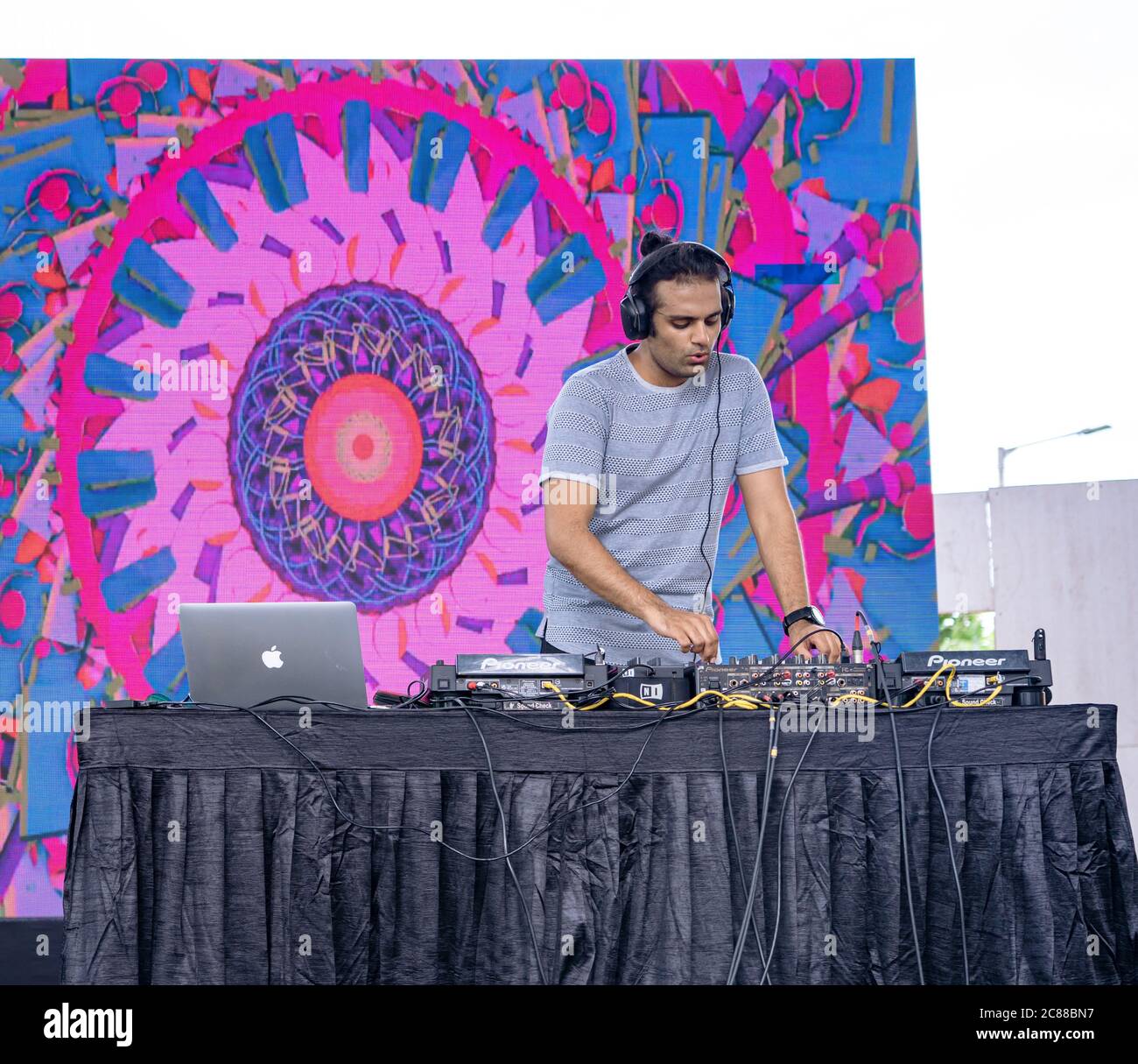 Ein professioneller DJ, der bei einem Festival Musik mit digitalen DJ-Plattenspielern spielt Stockfoto