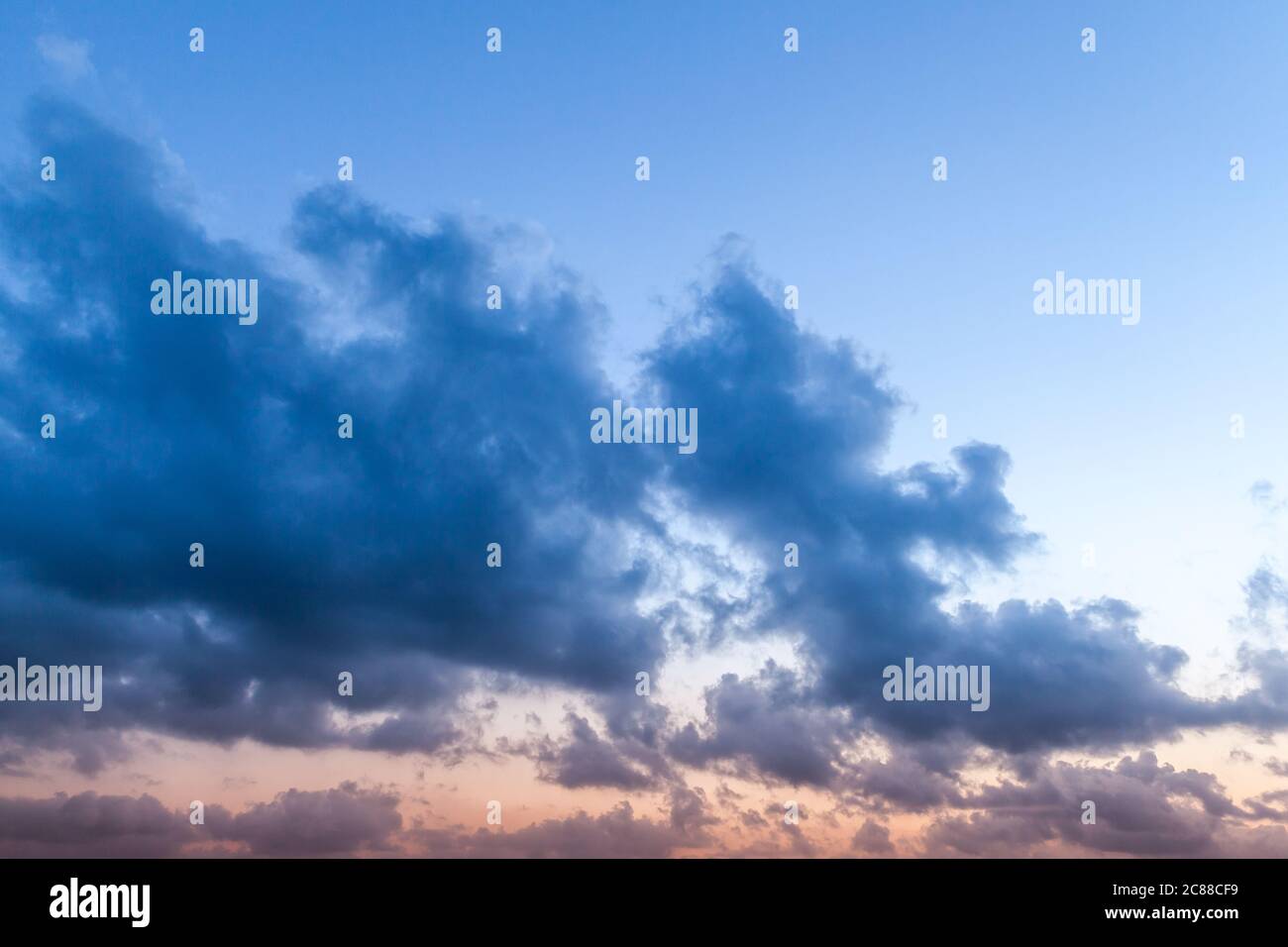 Dunkle Wolken am Himmel bei Sonnenuntergang, natürliches Hintergrundfoto Stockfoto