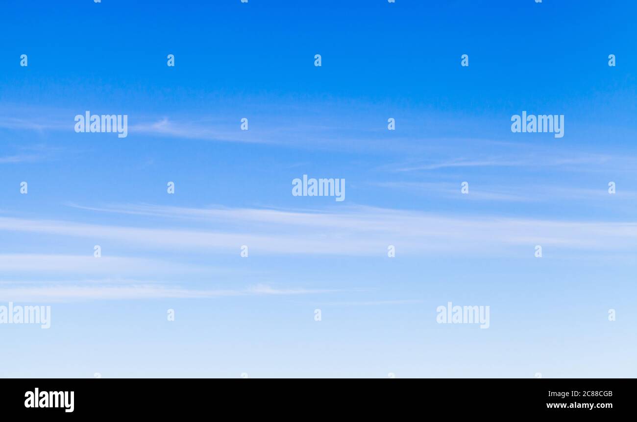 Blauer Himmel mit windigen Zirruswolken am Tag, natürliche Hintergrund Foto Textur Stockfoto