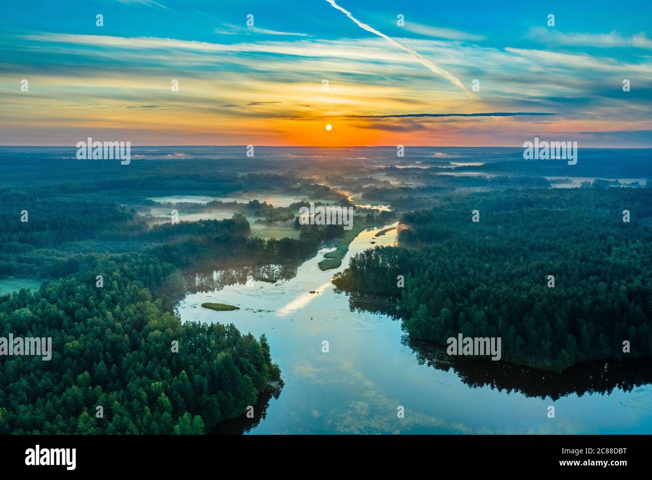 Sonnenaufgang oder Morgengrauen über dem Fluss. Sonnenuntergang über Wald oder See. Sonnenaufgang über der schönen Natur in gemäßigter Zone. Luftaufnahme. Stockfoto