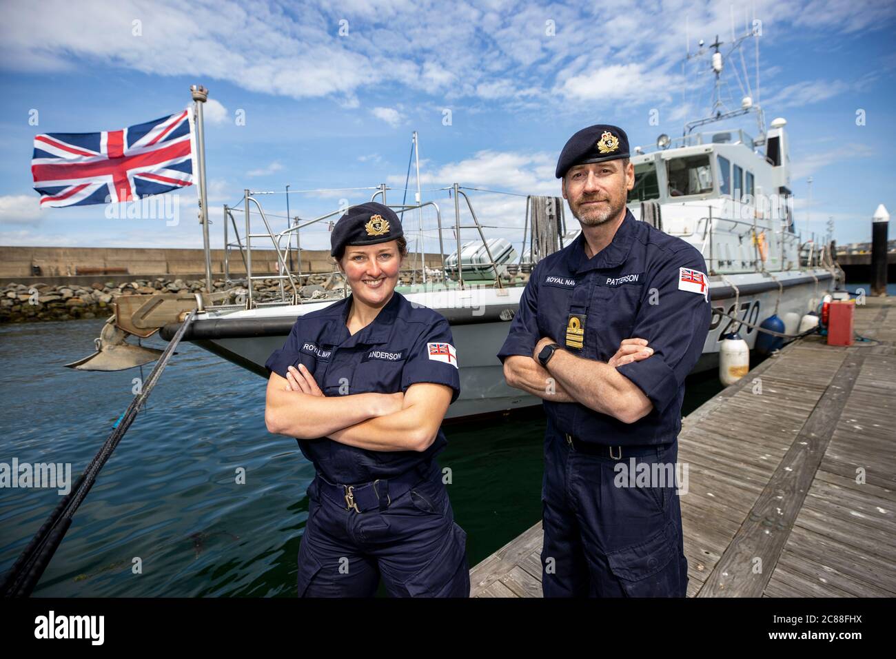 Kommandant LT Rebecca Anderson Royal Navy, und Senior Naval Officer Nordirland, Commander John Patterson, nach Ship's in Company Close-in Manöver entlang der nördlichen Antrim Küste, aufgenommen in Bangor Marina vor HMS Biter stehend. Die Coronavirus-Pandemie hat logistische Herausforderungen an Bord eines Kriegsschiffs ausgelöst, das die Kommandanten der Zukunft ausbildet. Stockfoto