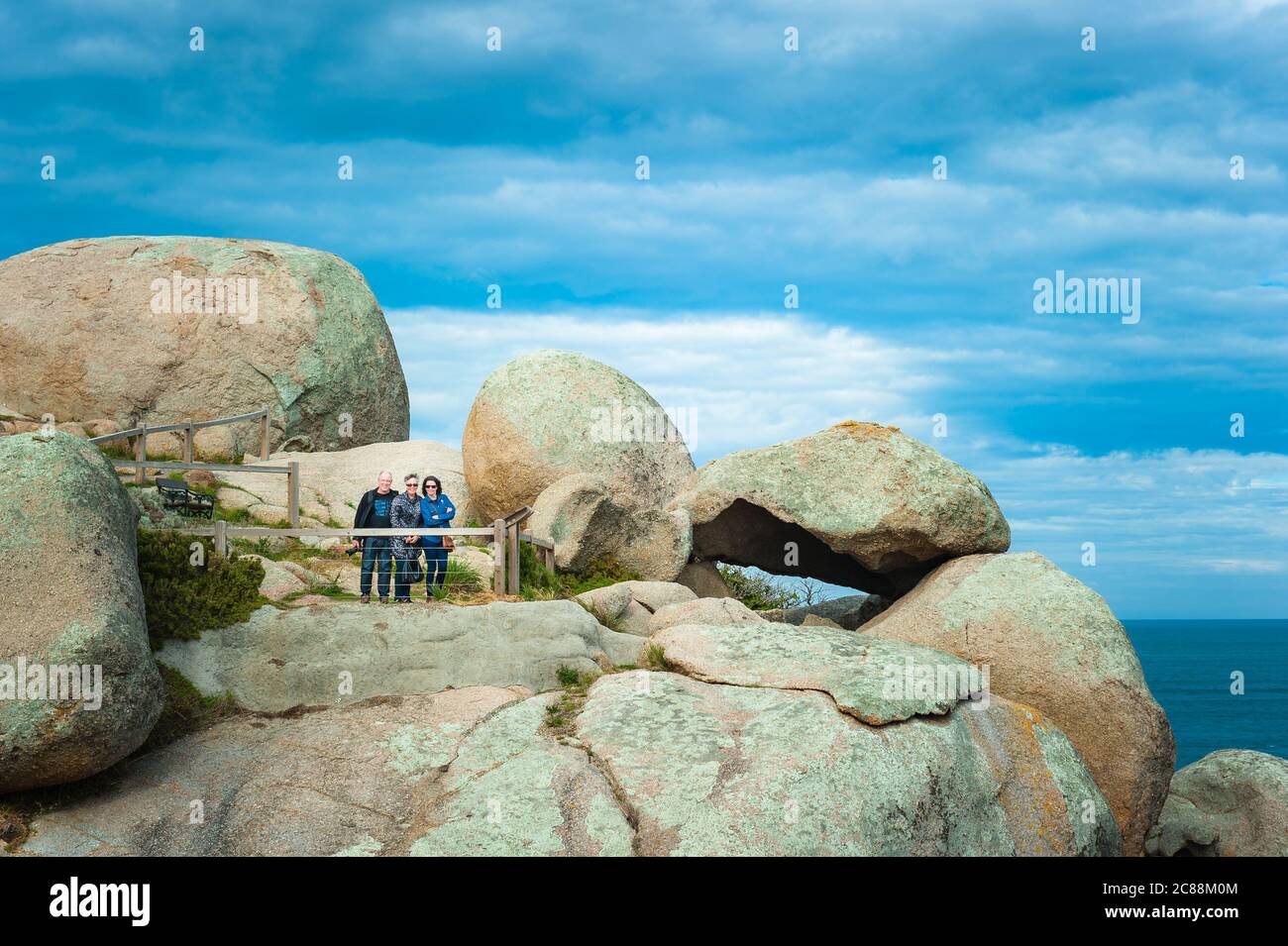 Eine kleine Touristengruppe liest auf einem Aussichtspunkt auf Granite Island, einer beliebten kleinen Insel mit erstaunlichen Felsformationen in Victor Harbor in Südaustralien. Stockfoto