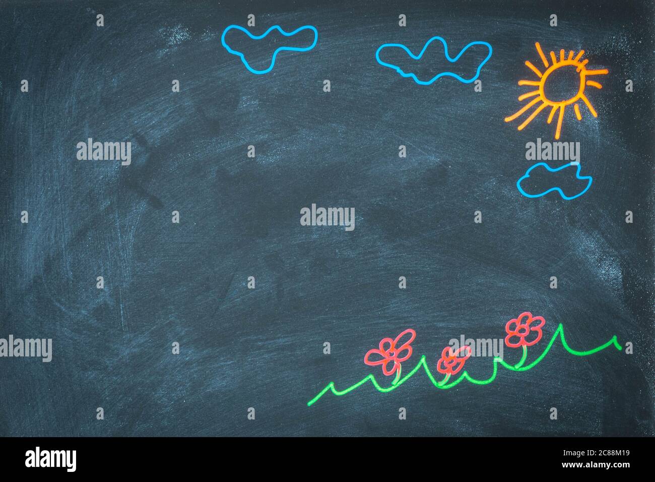 Farbige Kreidezeichnung auf Tafel für das Konzept der Schulrückseite. Draufsicht auf Tafel mit Sonne, Wolken, Blumen, Graszeichnung. Handgezeichnetes Bild Stockfoto