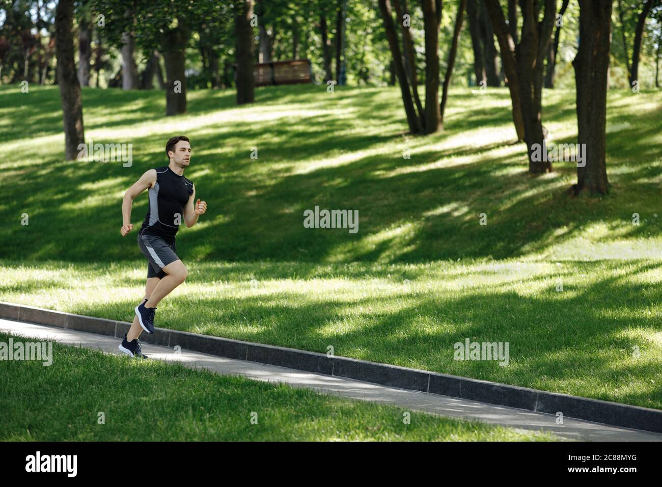 Urban Sport und Outdoor-Training. Muskulösen Kerl Fitness-Tracker läuft auf Pfad Stockfoto