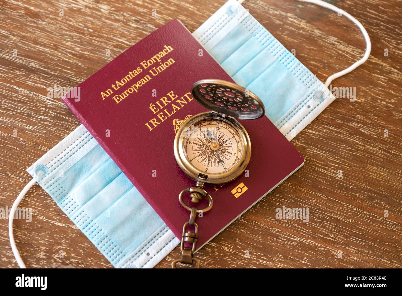 Irischer Reisepass auf Gesichtsmaske / Schutzmaske mit Kompass. Konzept Reisebeschränkungen Quarantäne aus Irland Coronavirus Covid-19 Stockfoto