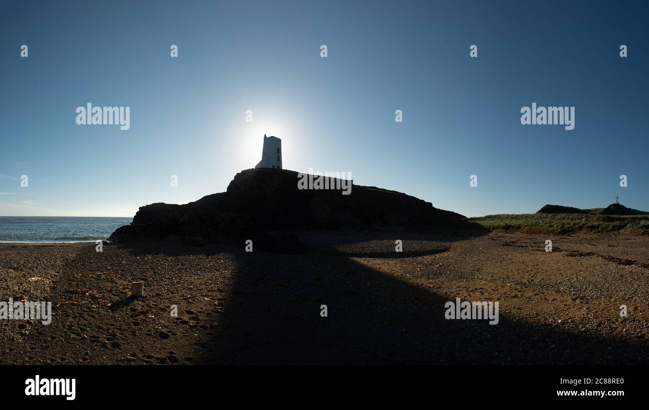 Nordwales Küste mit einer Sonne hinter dem Llanddwyn Leuchtturm, Großbritannien Stockfoto