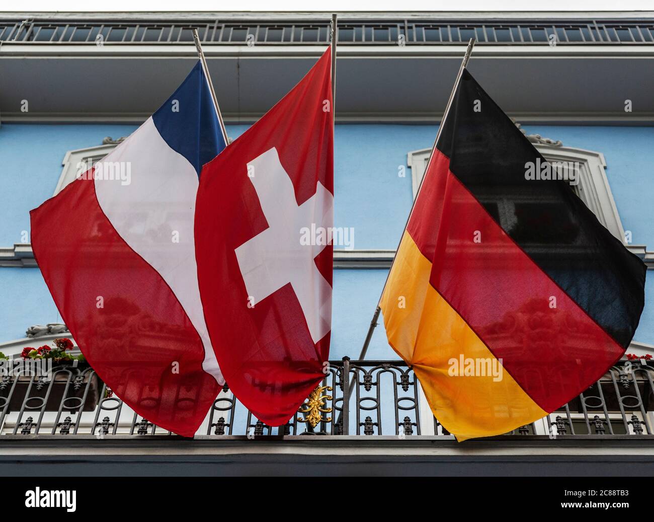 Französische, Schweizer und deutsche Flaggen hängen vom Hotelbalkon in Basel Stockfoto