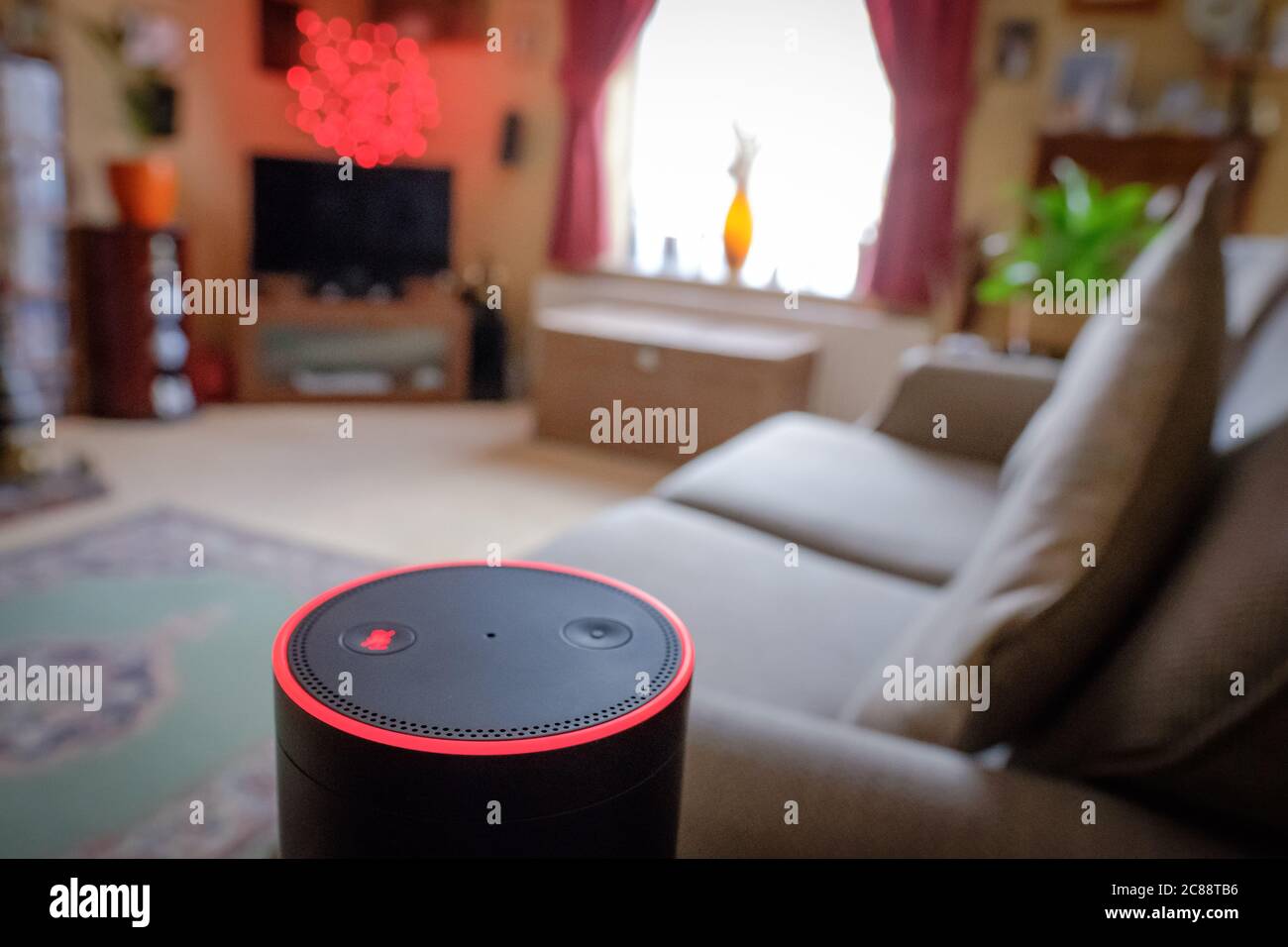 Flacher Fokus eines bekannten, digitalen KI-Personal Assistant in einem Wohnzimmer Ort gesehen. Zeigt den leuchtenden Ring und die Touch-Tasten an. Stockfoto
