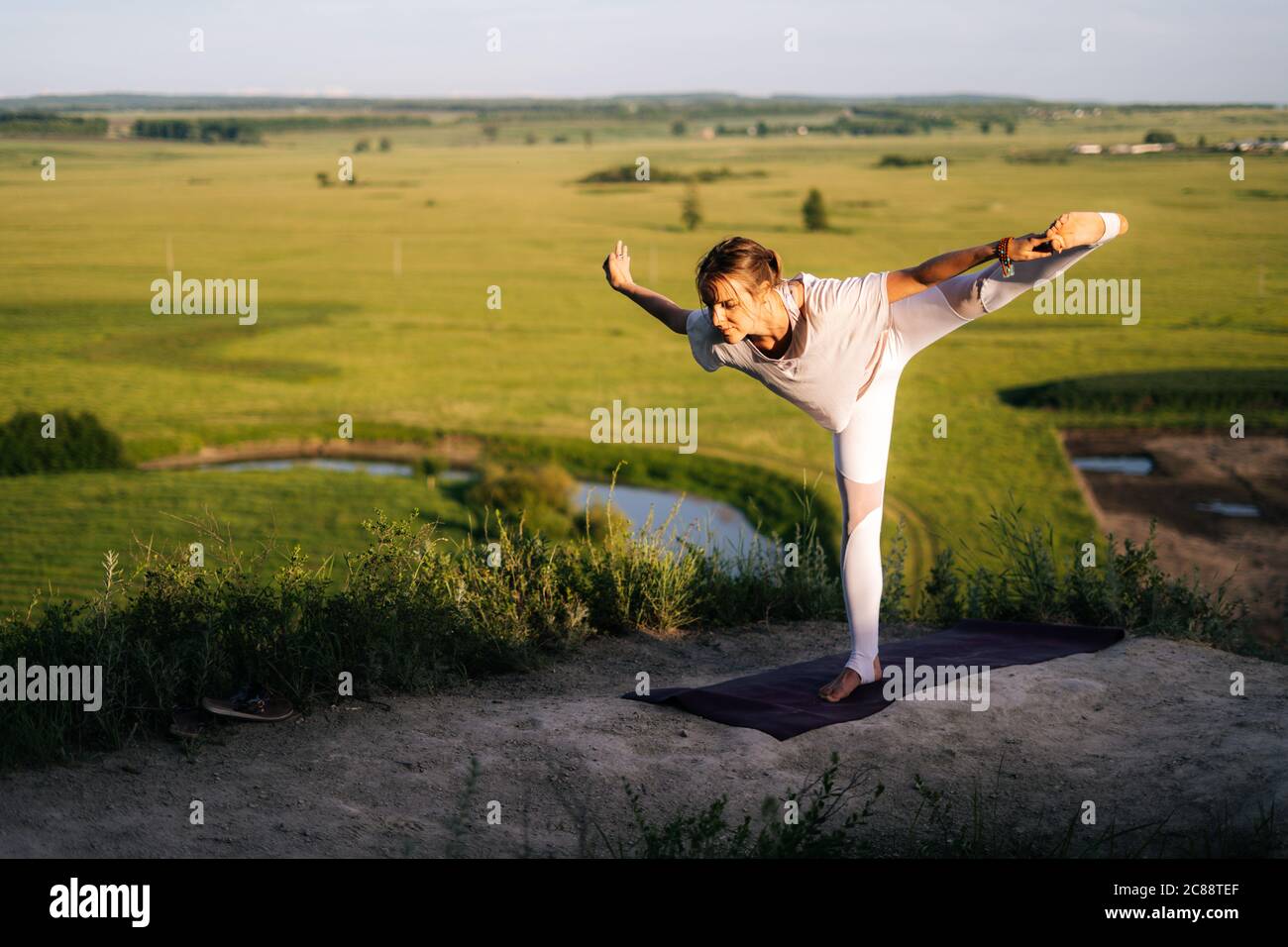 Sportlich fit junge Frau Yoga auf dem Rock Hintergrund des fließenden Flusses üben Stockfoto