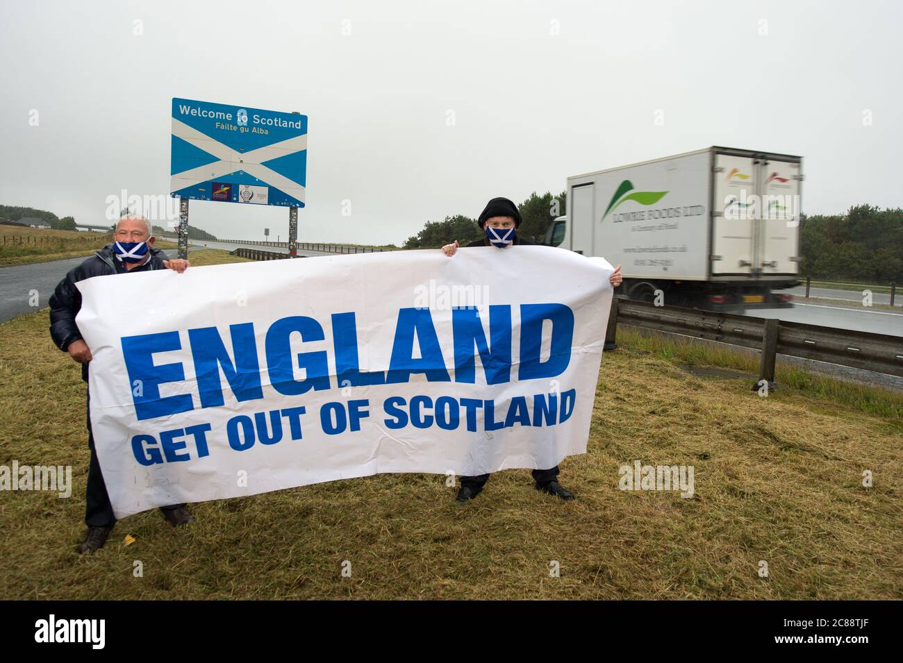 Schottisch/Englisch Grenze in Berwick, Schottland, Großbritannien. 22. Juli 2020 Foto: (L-R) James Connelly; Sean Clerkin von Action for Scotland. Alle Menschen müssen aufhören, von England nach Schottland zu reisen, aus unwesentlichen Gründen, um die schottische Bevölkerung vor Covid-19 zu schützen. Neue Fälle von Covid-19 sind 5.5-mal höher in England als Schottland und Professor Rowland Kao ein mathematischer Biologe an DER UNIVERSITÄT EDINBURGH erklärte kürzlich, dass, wenn es erhöhte Reisen zwischen England und Schottland ist es unvermeidlich, dass Fälle von Covid-19 wird in Schottland zunehmen. Quelle: Colin Fisher/Alamy Live News. Stockfoto