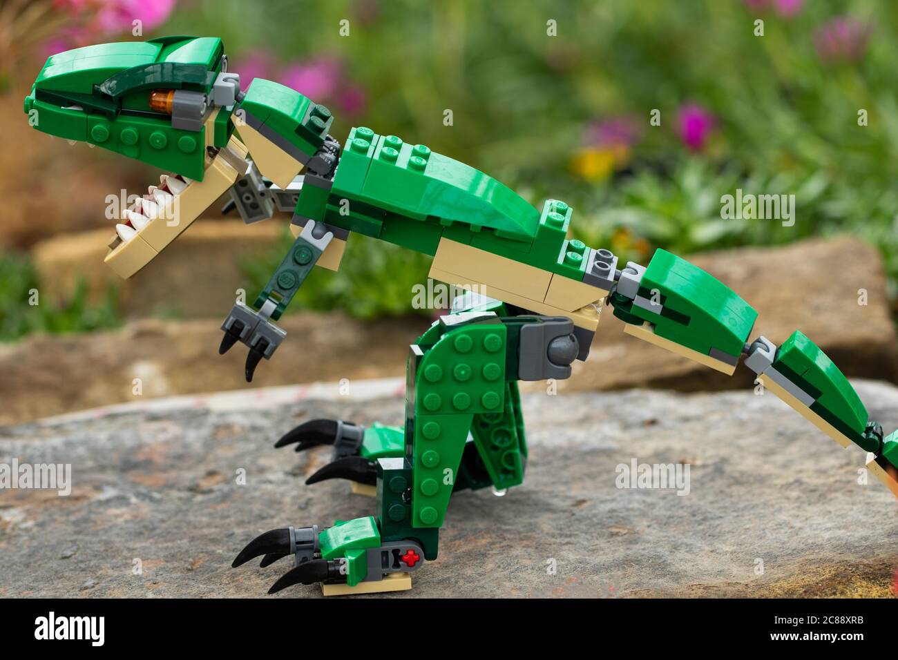Green Lego Dinosaur stand auf einem Felsen RHS Garden, Harrogate, North Yorkshire, England, Großbritannien. Stockfoto