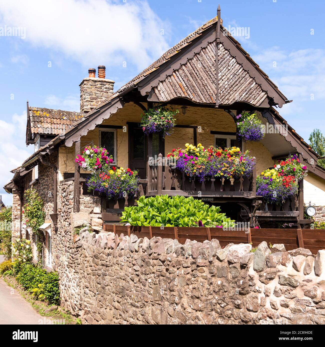 Ein Schweizer Chalet-Balkon auf einem alten Steinhaus im Exmoor Nationalpark im Dorf Bossington, Somerset UK Stockfoto