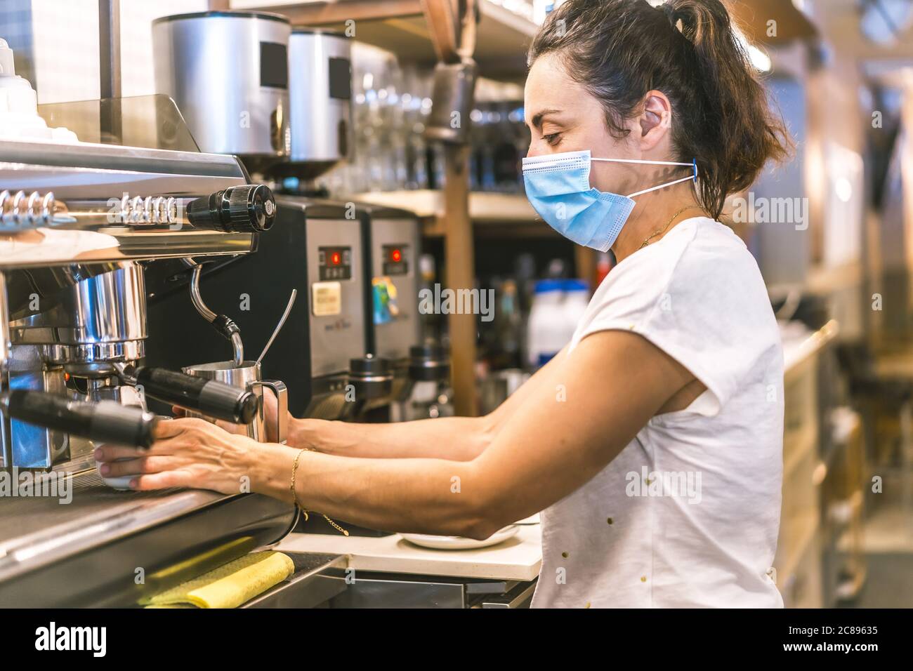 Kellnerin arbeitet an einer Bar bei der Wiedereröffnung, nach der Coronavirus Quarantäne Stockfoto
