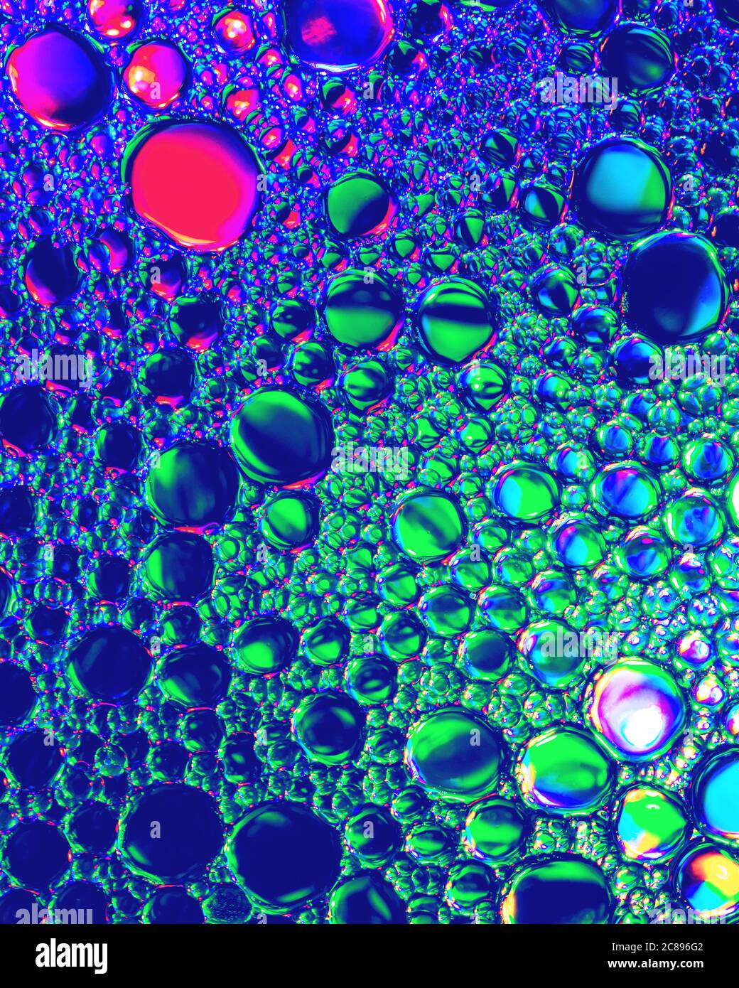 Draufsicht auf bunten Tropfen Öl auf dem Wasser. Blau, Grün und Violett farbige Kreise und Ellipsen. Abstrakte hellen Hintergrund für Design. Stockfoto