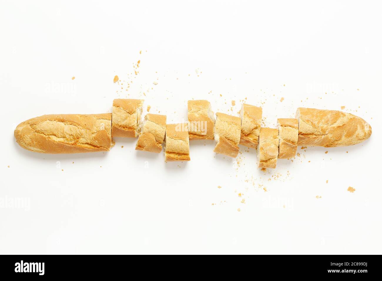 Draufsicht auf geschnittenes Baguette mit Krümel auf Weiß Stockfoto