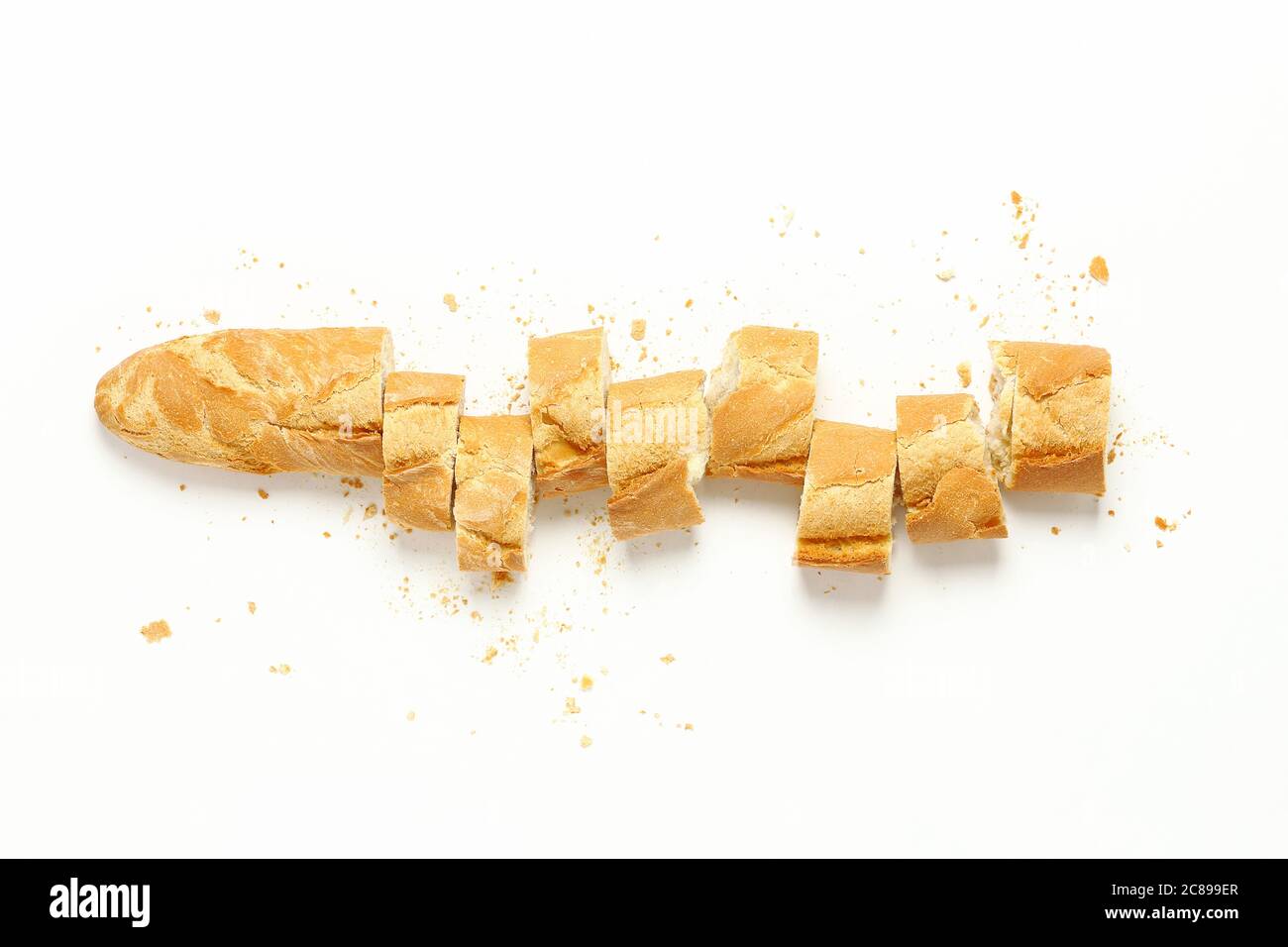 Draufsicht auf geschnittenes Baguette mit Krümel auf Weiß Stockfoto