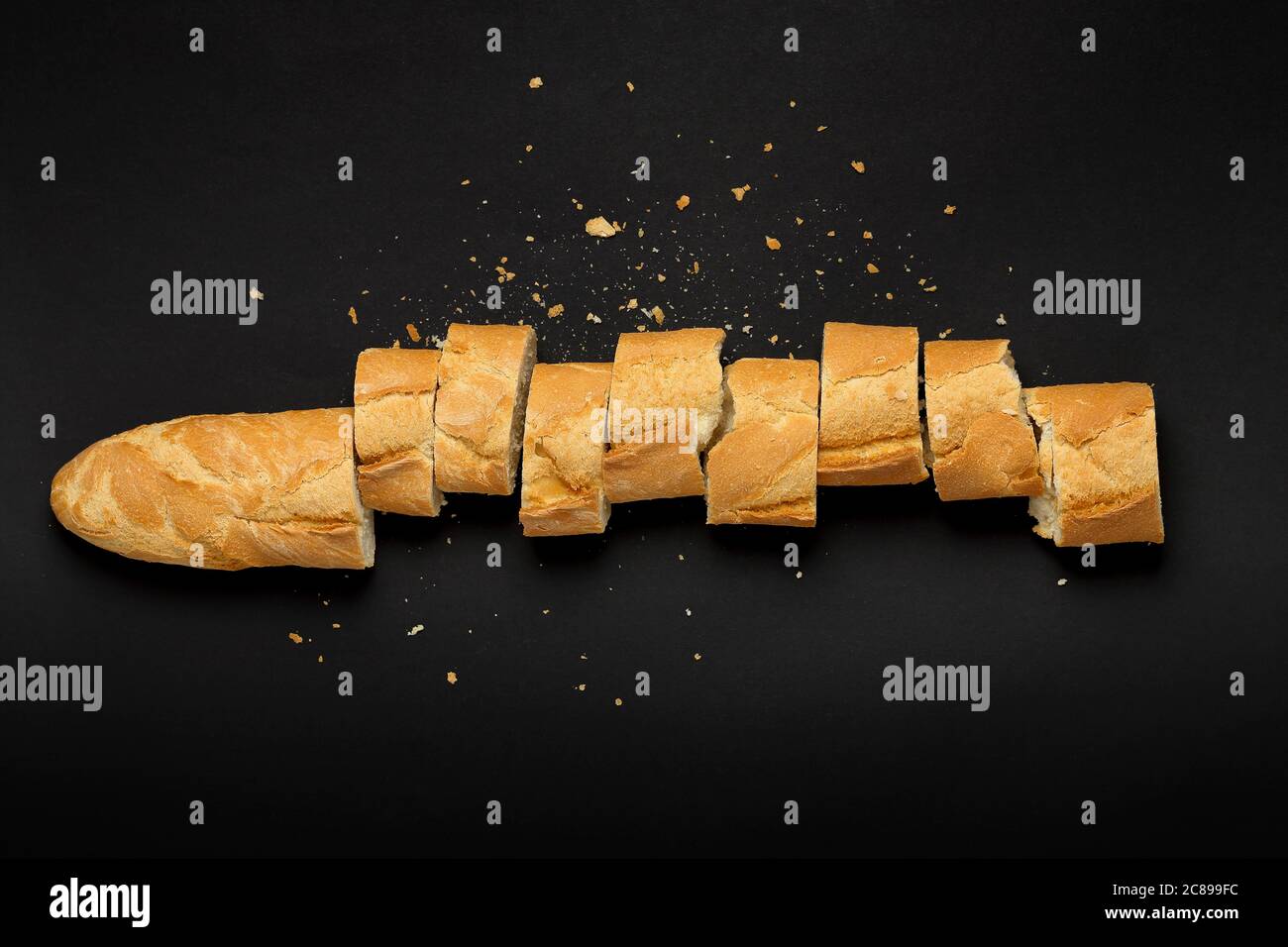 Draufsicht auf geschnittenes Baguette auf schwarz Stockfoto
