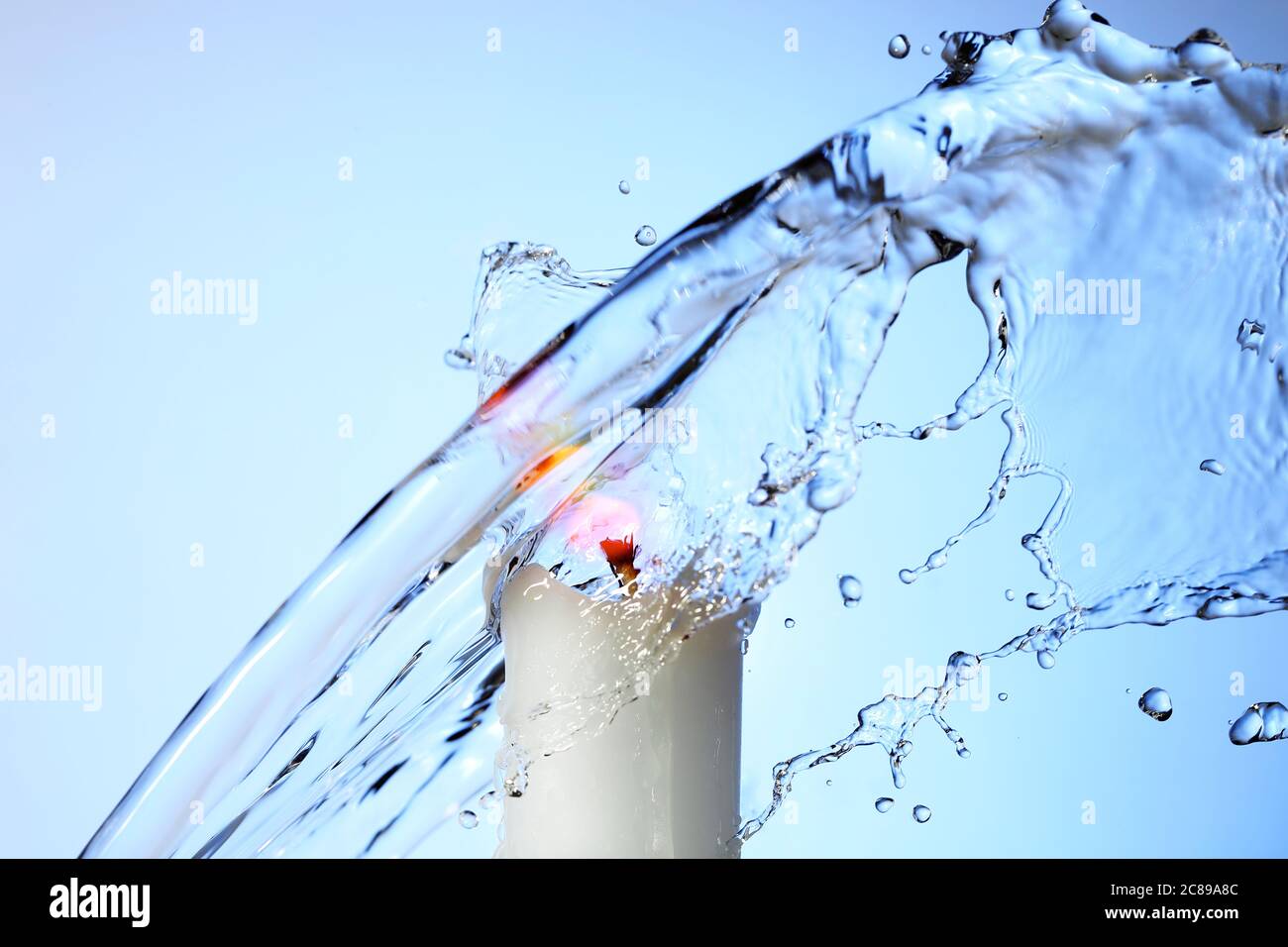 Wasser spritzt auf brennende Kerze gegen blauen Gradienten, abstrakte High-Speed-Fotografie Stockfoto