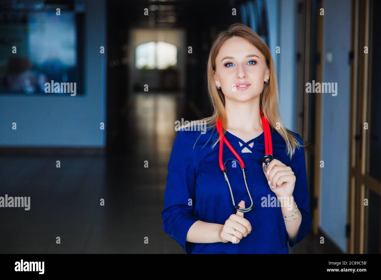 Medizinstudentin lächelt an der Kamera an der Universität in einem blauen OP-Anzug. Professionelle Mädchen Chirurg Arzt. Stockfoto