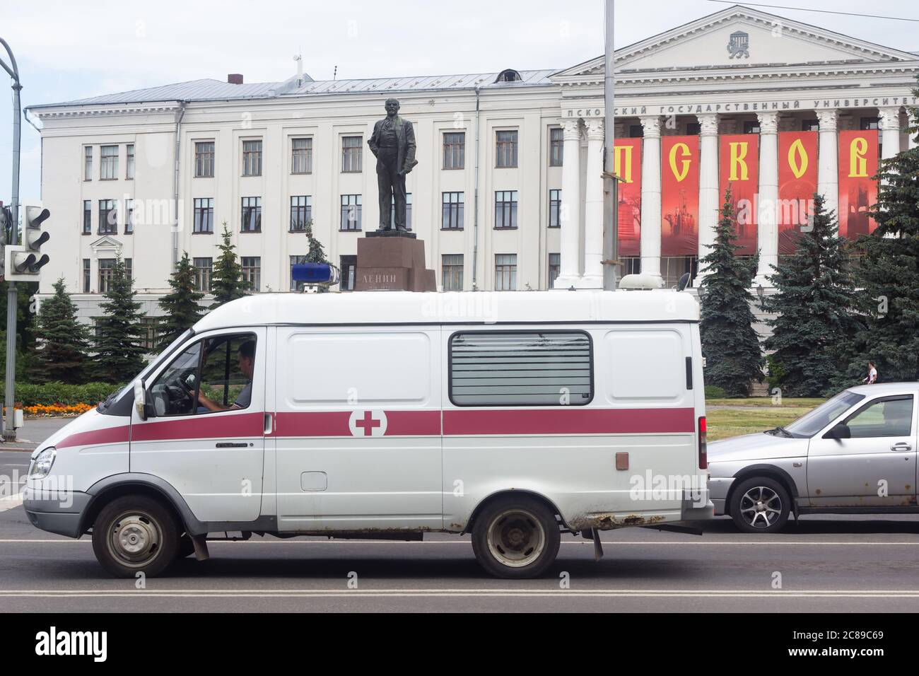 Ambulanz auf dem Hintergrund des Denkmals für Lenin und Pskow State University Stockfoto