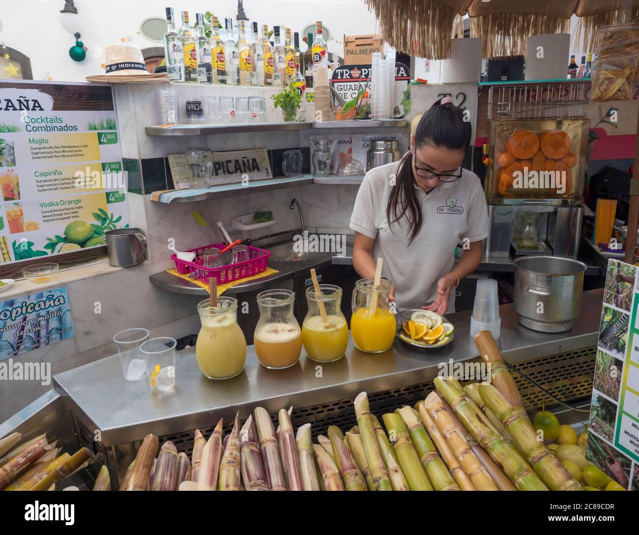Santa Cruz de la Palma, La Palma, Kanarische Inseln, Spanien, 23. Dezember 2019: Junge Frau bereitet frischen Saft und Cocktails aus Zitrusfrüchten zu Stockfoto