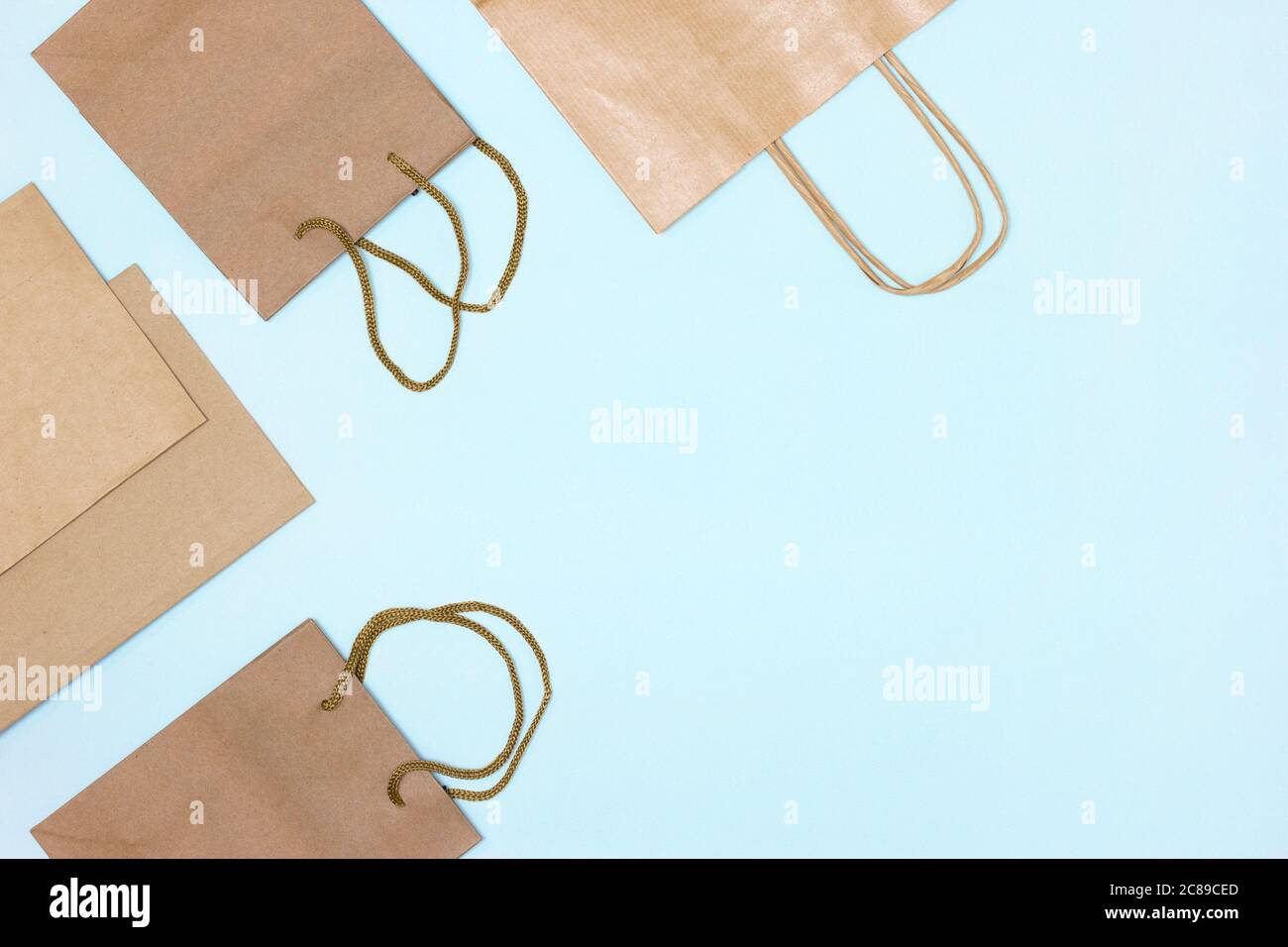 Papier Merchandise Taschen auf blauem Hintergrund, flacher Layrahmen mit Kopierraum. Shopping, Verkauf minimales Konzept Stockfoto