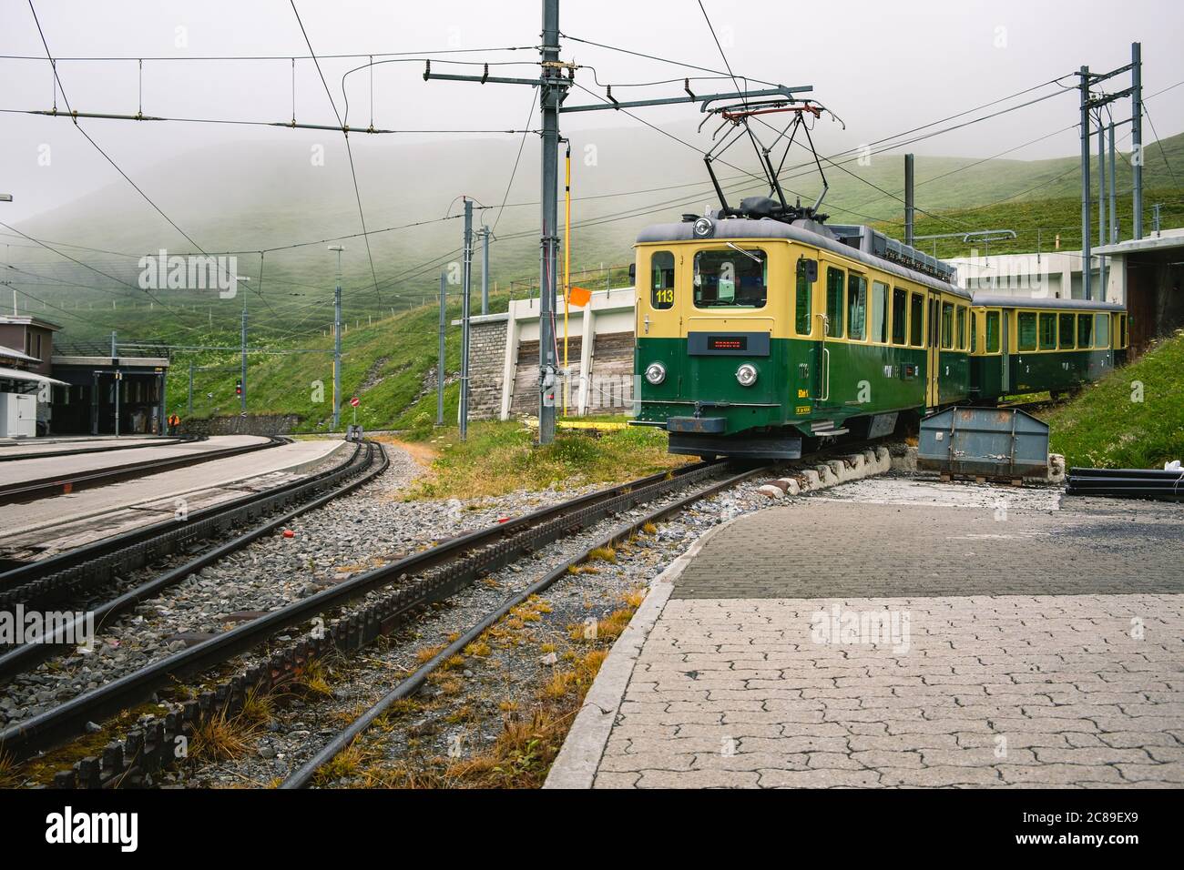 Kleine Scheidegg, Berner Oberland, Schweiz - Juli 31 2019 : Alter elektrischer grün-gelber Zug der Wengernalpbahn (WAB) mit Pantograph nach oben Stockfoto