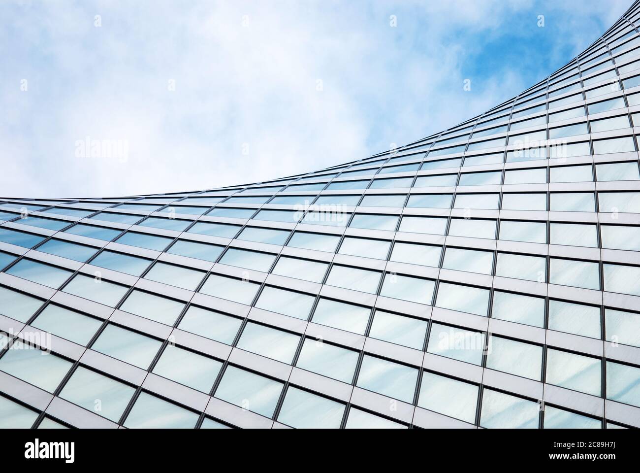 Abstrakte moderne Architektur, Glas-Außenstruktur, wellenförmige Gebäudedetails in blauem Himmel Stockfoto