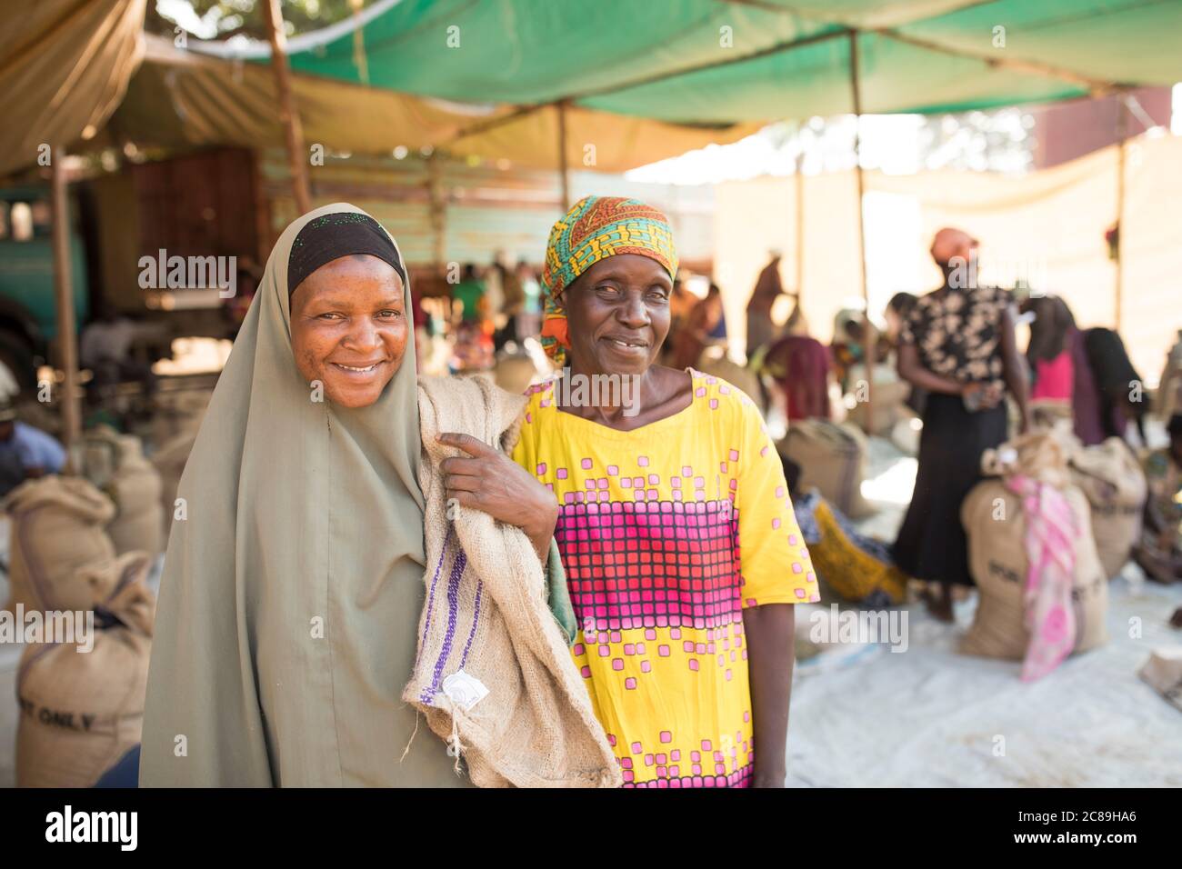 Arbeiterinnen sortieren und packen getrocknete Kaffeebohnen in einem kooperativen Lager eines Kaffeebäuers in Mbale, Uganda, Ostafrika. Stockfoto