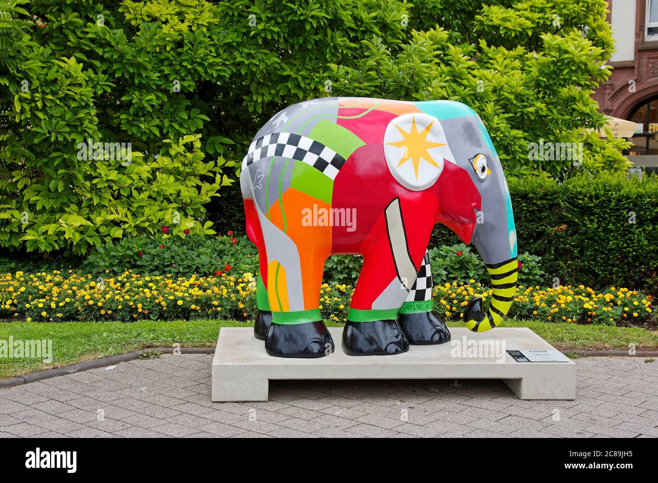 Asiatische Elefantenstatue, bunt, hell, moderner Stil, Tierförderung, Kunst im öffentlichen Raum, gelbe Blumen, grüne Vegetation, Europa, Trier; Ge Stockfoto