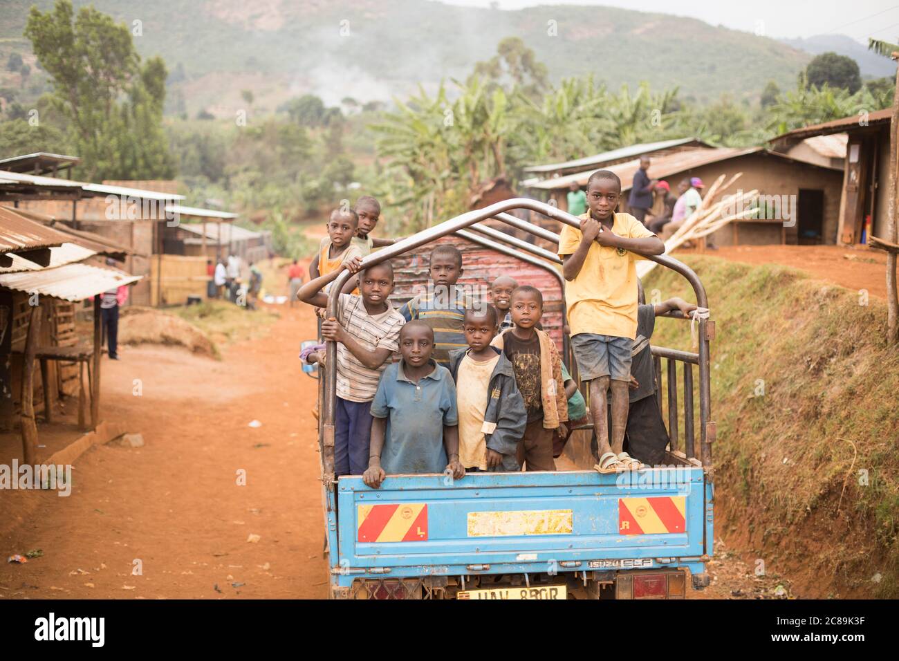 Kinder fahren auf dem Rücken eines LKWs auf den Ausläufern des Mount Elgon, Uganda, Ostafrika. Stockfoto